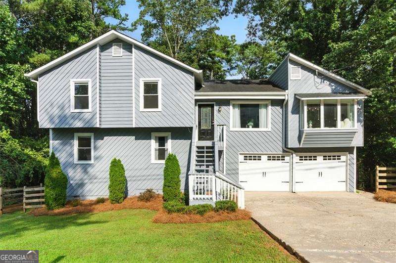 Welcome to this beautifully updated, split-level home at 5100 Ravenwood, just 12 minutes from the vibrant downtown Woodstock. Perfectly situated in a top-rated school district, this residence combines modern open-concept living with practical, versatile spaces, making it an ideal retreat. Upon entering, you are greeted by an open main living area featuring soaring high ceilings that create an expansive and airy atmosphere. The well-designed layout seamlessly connects the living, dining, and kitchen areas, making it perfect for entertaining. The kitchen features new stainless steel appliances and plenty of counter space for all your culinary needs. Large, newer windows flood the space with natural light, highlighting the fresh paint and elegant finishes. The home's unique split-level design offers incredible flexibility. The lower level provides a secondary living area, a full bedroom, and a full bathroom, offering a private and comfortable space for a teen suite, in-law quarters, or a guest retreat. The spacious master bedroom features new flooring, creating a fresh and modern feel. The ample garage space includes dedicated storage, a major bonus for keeping your home organized and clutter-free. Outside, the property is a true haven. The owner has thoughtfully cleared many trees to create a spacious, usable, and fully fenced-in yard. Recent landscaping adds to the home's curb appeal, providing a beautiful and private outdoor space for relaxation, recreation, and pets. The roof is in good condition, giving you peace of mind from the moment you move in. With its recent painting, newer windows, and proximity to top-rated schools, nearby grocery stores, and a shopping center, this home is more than just a place to live-it's a place to thrive. Don't miss the opportunity to make this exceptional property your new home.