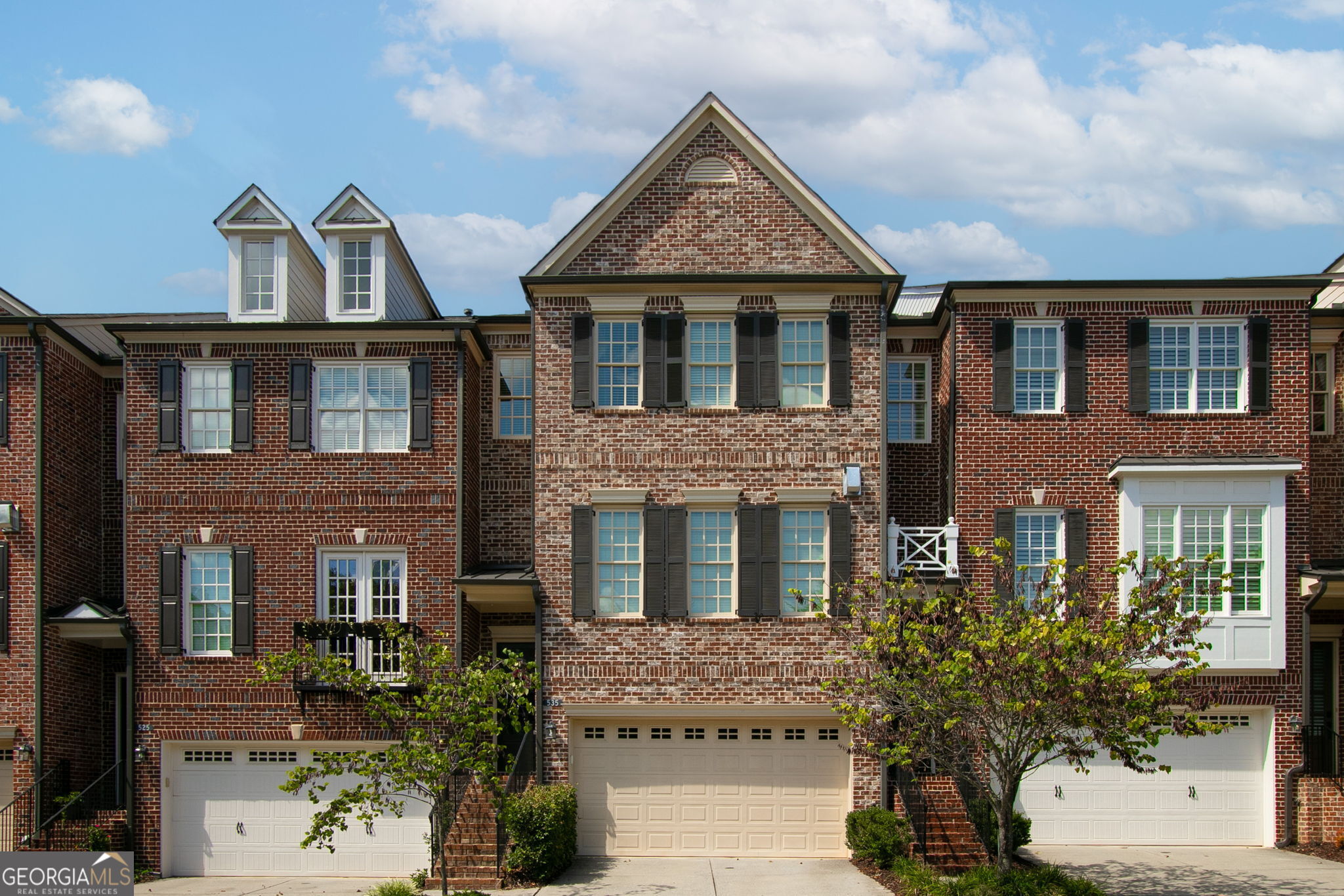 Prime Downtown Alpharetta Location!!! Welcome to 535 Rose Garden Lane in Awesome Alpharetta! Steps away from amazing dining, shopping, the Alpha-Loop Walkway, The Green Downtown Entertaining Area, parks and all of the amazing events this Top Rated city has to offer. This beautiful 4 bedroom, 3 1/2 bath home is located in one of the premier neighborhoods of the downtown district. You'll enjoy plenty of parking with a double garage, double driveway and guest parking. On the main level you'll find a spacious and open entertaining-style living area, dining area and kitchen with a walk-in pantry, soaring ceilings, a fireplace, built-ins and access to your balcony. The spacious primary bedroom is located on the third level with a large walk-in closet and in the primary bathroom you'll find a soaking tub, walk-in shower and a double vanity. Also on this level are 2 comfortably sized guest rooms (one with a walk-in closet), a full bath with a double vanity and a conveniently located laundry room. On the lower level is a large bedroom/den with a full bath and direct access to the cozy and private backyard with fenced room for your fury friends. The wooded lot offers privacy in the rear of the home with no other yard directly behind. New interior paint throughout and 3rd floor hardwood. This beautiful home is located in a very quiet and peaceful section of The Georgian Townhome Community in Alpharetta, consistently ranked as one of the top places in the country to live, work and play. Come see why we call it Awesome Alpharetta!