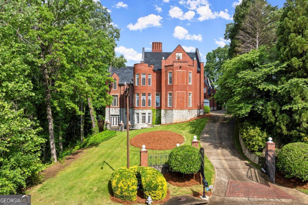 Majestic Estate Inspired by the Castles of England and Scotland - Sale Includes Two Adjoining Lots - three parcels, see last picture! Buy all and sell or build on the others! Bordering the National Park and nestled beside scenic Sope Creek, this breathtaking estate draws inspiration from the timeless castles of England and Scotland. Meticulously crafted over three years, this architectural masterpiece combines old-world grandeur with modern luxury and includes the adjoining two lots for added privacy and expansion potential. From the moment you enter, you're surrounded by masterful details: rare Honduran mahogany, hand-carved doors, antique imported mantels from 200-300-year-old English manors, and European chandeliers throughout. A soaring 25-foot Great Room with hand-hewn beams offers a dramatic central gathering space, while the richly paneled Library/Office and elegant Dining Room with fabric-paneled walls exude character and sophistication. The gourmet Kitchen features a large island, walk-in Pantry, Butler's Pantry, and a cozy Keeping Room with fireplace, all opening into a Breakfast Room with tranquil views of the natural beauty of Sope Creek. A main-level Suite with fireplace provides comfort and privacy for owners or visitors. The grand two-story Entry Foyer features a sweeping mahogany staircase, complemented by a rear staircase accessing all levels. Upstairs, the expansive Second Primary Suite includes its own fireplace and private Laundry, along with two additional ensuite Bedrooms. A private hallway leads to the Carriage House, offering independent living space complete with Living Room, Kitchen, Bedroom, Bathroom, and Laundry. Two lower levels overlook a show-stopping, two-story Recreation and Gaming Hall featuring a massive 30-foot stone fireplace-perfectly suited for entertaining, art displays, or hosting grand events. The home is elevator-ready, with a shaft already in place, and includes existing plumbing for a future pool featuring cascading waterfalls from the main house. Car enthusiasts and collectors will appreciate the oversized five-car Garage, with two climate-controlled bays and generous storage. The Carriage House is accessible via an interior staircase for convenience. This one-of-a-kind estate was constructed with only the finest materials and an uncompromising attention to detail. It's more than a home-it's a legacy property, ready for you to make your own. Note: Bedroom/Bathroom count includes 1BR/1BA in the Carriage House Apartment. Pool design plans available.