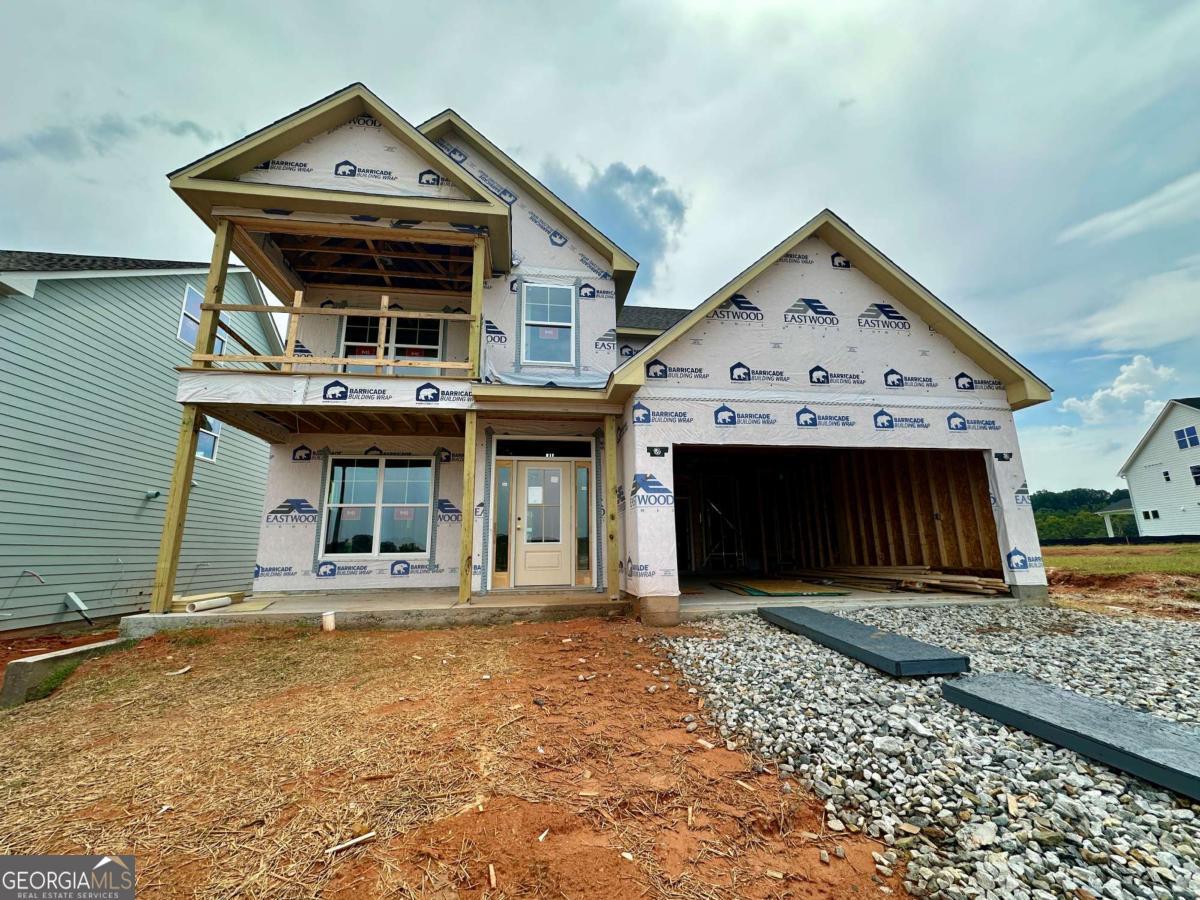 Eastwood Homes presents the Cypress plan at Twin Lakes, scheduled for completion in December. This stunning 4 bedroom, 3 bath home offers both style and function, starting with its charming double front porches, including an upstairs porch off the loft - the perfect place for morning coffee or evening sunsets. Inside, the main level is designed for modern living with a private guest suite, a dedicated office, and a screened-in back porch that extends your living space outdoors. The open-concept family room features a cozy fireplace and flows seamlessly into the kitchen, where crisp white cabinetry, a bold navy island, quartz countertops, and gold accents create a space that is as beautiful as it is functional. Upstairs, the loft makes an ideal second living area and opens directly to the upper porch for a unique outdoor retreat. The primary suite is a true getaway with spa-inspired finishes in calming gray and white tones accented by gold details, while the additional bedrooms and baths continue the home's elevated, cohesive style. A generous backyard completes the package with room to entertain, garden, or simply unwind. Twin Lakes offers resort-style amenities with two sparkling pools, a clubhouse, fitness center, playgrounds, scenic walking trails, and, of course, two beautiful lakes at the heart of the community. Perfectly situated just minutes from I-85, you'll have quick access to downtown Braselton and Hoschton, where some of the area's best restaurants, shops, and breweries await. Plus, Hoschton's calendar is full of festivals and community events, giving you even more reasons to love where you live.Special Financing: $6,000 in closing costs with the builder's lender, Sabal Mortgage.