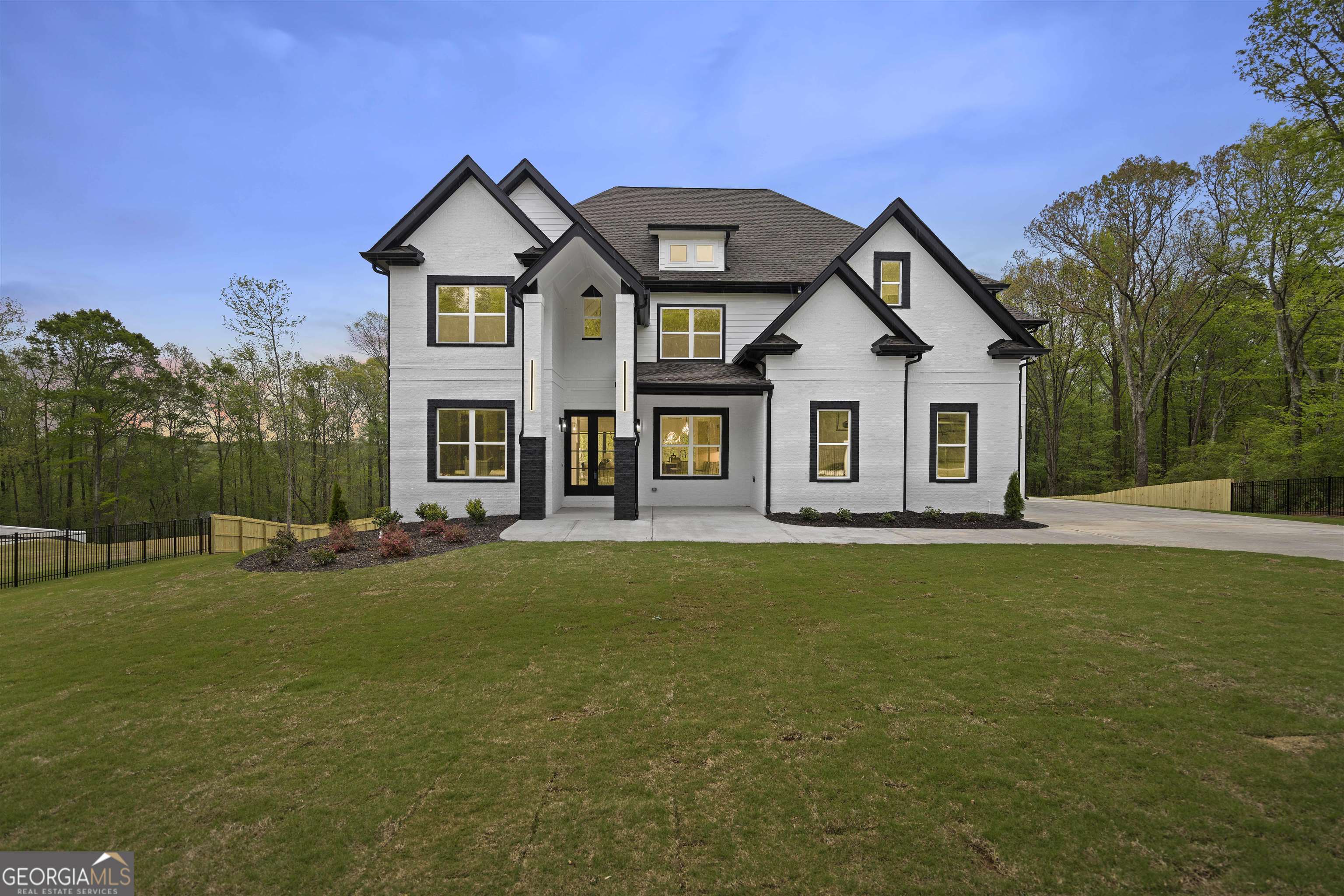 This private gated modern luxury home is located on the end of an enclave of new construction homes. The well-appointed floor plan with a basement boasts an open floorplan with the perfect balance of modernist and traditional finishes. As you enter the home you'll notice the entire home has an abundance of natural lighting. The main level features open-concept living; white oak hardwood floors, a private home office, spacious dining area with a contrasting and modern design accent wall, a secondary bedroom, half bathroom, a spacious and functional family room, a Chef's kitchen and a covered patio. As you enter the home you will notice modern black hardware and lighting fixtures. The chef's kitchen is equipped with high-end appliances, including a six burner gas cooktop stove, a built-in oven and microwave, oversized walk-in pantry, white custom ceiling height cabinets and extended white quartz countertop with black veining the island has black cabinets for a modern contrast that leads into the family room which is perfect for entertaining friends and family. The Family room features a custom coffered ceiling, electric fireplace surrounded by porcelain and finished with modern shiplap and built-in bookshelves and cabinets. You have a view and direct access to the covered patio with a fan and staircase that leads to the flat backyard and basement from the family room. The eat-in dining room is situated in the perfect location with additional cabinets for storage and functionality. The secondary ensuite bedroom on the main level is stunning, featuring a frameless shower and its own laundry connections. The is a mudroom located just off of the 3-Car garage with access to a small hallway with access through the kitchen and the secondary bedroom that features a full bathroom frameless shower and washer and dryer connections. As you walk up the modern staircase to the upper level you are greeted by an elevated loft that features built-in bookcases, an electric fireplace, and tray ceilings. The Owner's Suite was meticulously designed as an optimal and exquisite retreat for rest and relaxation; a gray and white porcelain tiled grandiose-sized walk-in shower with dual rain shower heads and a separate soaking tub await you. As you walk through the bathroom you arrive at the Owner's Suite walk-in closet is fully custom for the ultimate dressing room experience day after day. Each additional bedroom is generously sized. The unfinished daylight basement is stubbed and ready for your customization Situated just minutes from Little Mulberry Park - a scenic park with soft-surface trails for horses & hikers, plus a fishing lake & disc golf course. Less than 10 minutes from Chateau Elan Winery Golf Club and Resort. And built in an above-average school system, this location is prime! This property exudes convenience in every sense with the excellent location, great floor plan, and incredible price. This home is complete and ready to move in. This is your opportunity to own a stunning move-in ready Cornell Floor Plan built by Nick & Brothers.