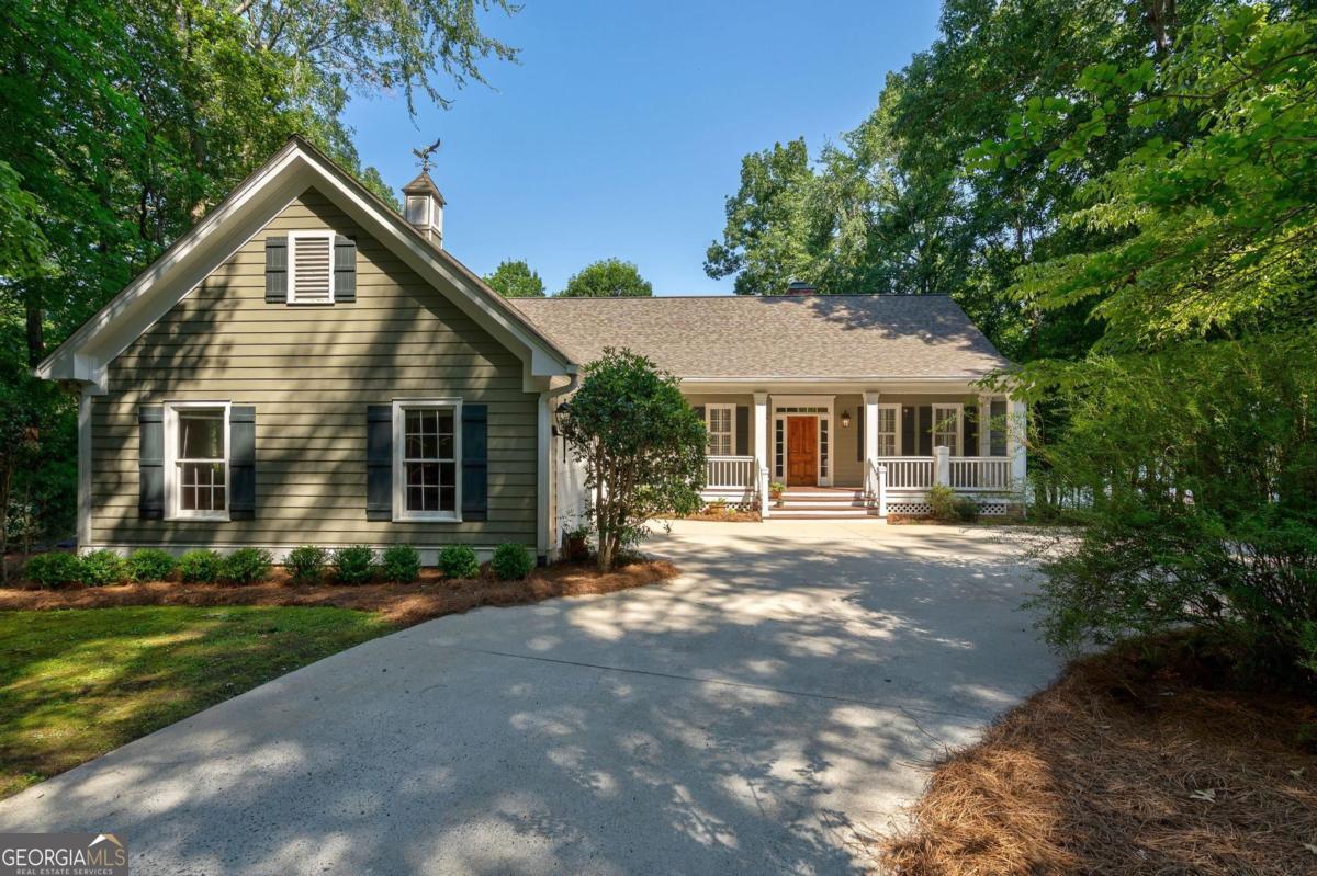 Discover timeless Southern elegance and luxury lakefront living in this custom-built 5-bedroom, 3.5-bathroom estate located in the prestigious Great Waters community at Reynolds Lake Oconee. Situated on a prime waterfront lot with a max dock and boat lift, this home offers stunning views that only Lake Oconee can provide. From the moment you arrive, a circular driveway and mature landscaping create a warm, private, and welcoming first impression. Step inside to find heart pine floors, tongue-and-groove ceilings, and solid construction details that give this home both character and comfort. The main floor features a spacious master suite with his-and-hers counters, jetted tub, separate shower and adjacent laundry for ultimate convenience. The lakefront breakfast room, cozy den with masonry fireplace and gas logs, and screened porch overlooking Lake Oconee set the tone for peaceful mornings and unforgettable sunsets. Also on the main level, two well-appointed bedrooms - one with a lakeside porch, share a Jack & Jill bath, ideal for guests or family. Downstairs, the finished walk-out basement offers even more living space with a kitchenette/wet bar, game area, two bedrooms, a boat garage/workshop, and a large unfinished utility room for storage or future expansion. A second masonry fireplace with gas logs adds charm and warmth to the lower level. Ready for your personal touches, this one will be a gem in your purse! Whether you're enjoying a quiet evening by the fire, entertaining lakeside, or heading out on the water from your private dock, this exceptional property offers a rare opportunity to own a true Lake Oconee legacy home. Owner is making a golf membership available. Call or text Anna O'Neal - Ansley Real Estate Christie's International. 706-988-5698
