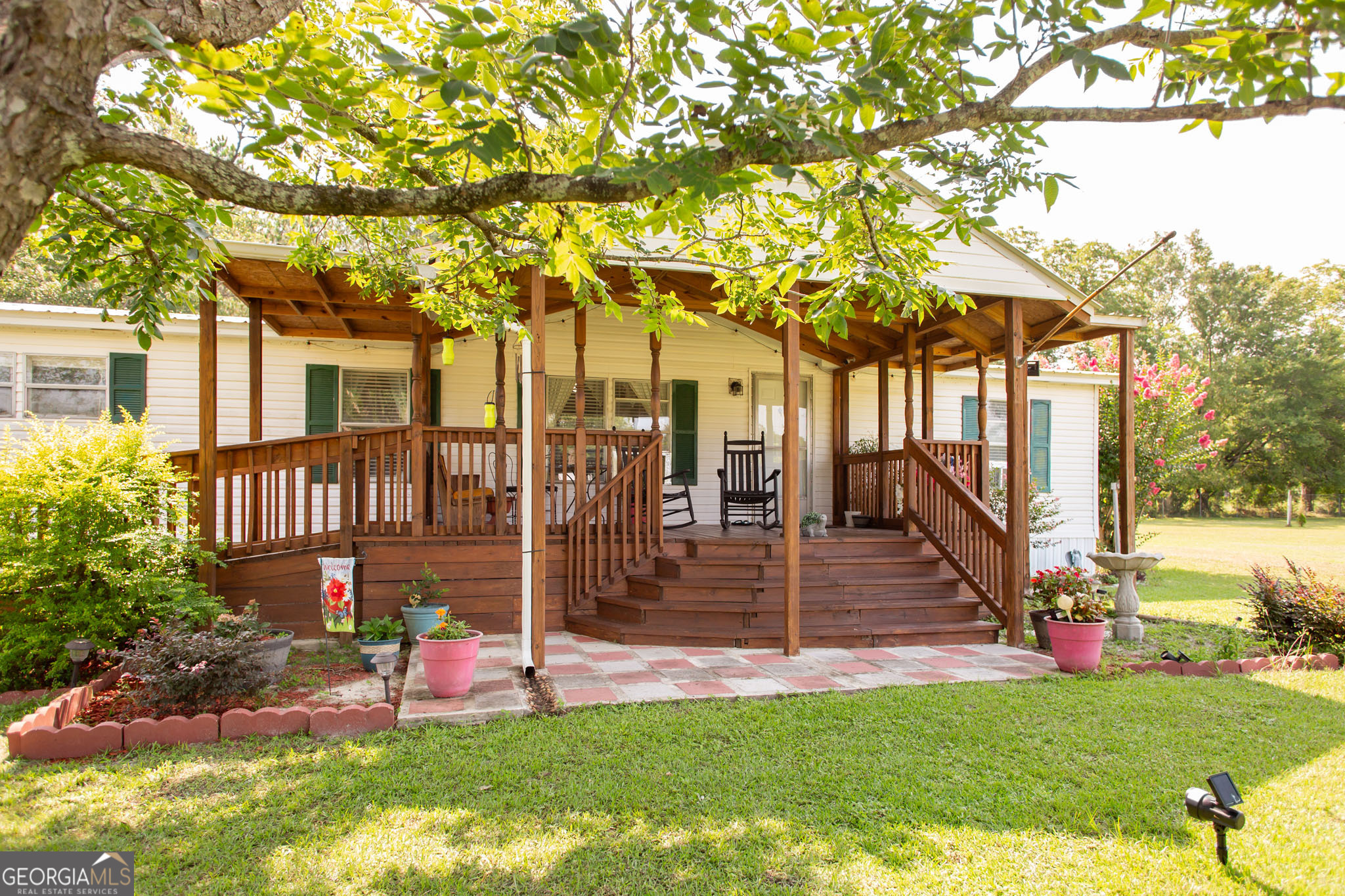 Welcome to your spacious, move-in-ready mobile home situated on a beautiful 1.61-acre lot! This well-maintained home features 4 bedrooms and 2 bathrooms, with walk-in closets in 3 of the 4 bedrooms. The primary suite offers a true retreat, complete with an en suite bath showcasing a dual vanity, separate tub and shower, and an additional flex room perfect for a nursery or home office. Enjoy multiple living spaces, including a cozy living room and a separate den with a wood-burning fireplace last used in 2024. Recent updates include new flooring (2025) in select areas and a Culligan water system installed in 2023 at the well and kitchen. This home has central heat. A/C is provided with window units that will convey with the home. Step outside to the large front porch with a wooden ramp for easy accessibility, or head out back to your screened-in porch, which leads to a spacious deck and 24' above-ground pool - the ideal setup for summer entertaining. The backyard features additional fenced-in space for pets, lovely landscaping, and most of the property perimeter is already fenced. This home offers a wonderful balance of peaceful outdoor living and spacious interior comfort - schedule your tour today and make this slice of country life yours! Note: Road paving is scheduled to begin August 2025!