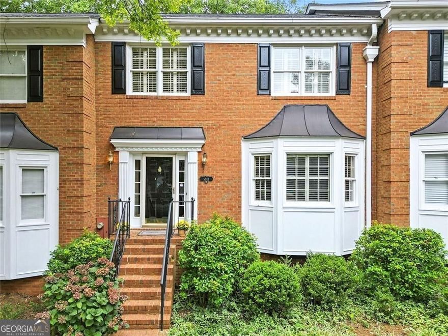 Brick elegance meets modern updates in this thoughtfully maintained three-bedroom, three-and-a-half-bath home with two spacious primary suites. The timeless exterior features stately black shutters, crisp white trim, and a welcoming brick stairway framed by lush landscaping, all while located in a quiet cul-de-sac surrounded by trees.  Inside, the kitchen offers granite countertops, stainless steel appliances, and abundant cabinetry, plus a built-in desk for organization. A pass-through window connects the kitchen to the living space, making hosting effortless.  The living room is anchored by a gas fireplace with a detailed mantel, flanked by built-in shelving, and illuminated by French doors leading to a bright sunroom with skylights. Hardwood floors and crown molding flow throughout the main level, while the finished basement provides fresh flooring, recessed lighting, and barn doors-ideal for a media room, home gym, or office. The fully renovated lower-level bath showcases a marble-topped vanity and a glass-enclosed shower with custom tilework.  Upstairs, two primary bedroom suites offer generous layouts, walk-in closets and private baths. Additional features include a two-car garage with high ceilings and an abundance of storage.  Enjoy a low-maintenance lifestyle with yard care and exterior upkeep covered by the homeowners association. The community pool is just steps away, and you're within walking distance to Dunwoody Country Club, coffee shops, groceries, restaurants, and more. Located in the high sought after Vanderlyn Elementary School District.