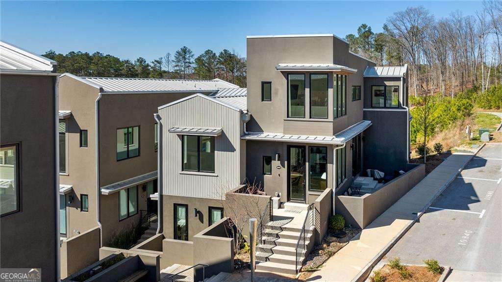 2 Car GARAGE! Welcome to 10944 Serenbe Lane, a sophisticated haven nestled in the heart of Chattahoochee Hills' Serenbe community. This elegantly modern residence offers an exceptional living experience, boasting 1,824 square feet of meticulously designed space. Upon entering, you are greeted by a foyer that sets the tone for the exquisite interiors that follow. The open layout seamlessly connects the living areas, highlighted by high ceilings and rich hardwood floors that exude a sense of luxury. The home features two spacious bedrooms, each with its own en-suite bathroom, offering a perfect blend of comfort and privacy. An additional half bathroom enhances convenience for guests. The primary suite is a sanctuary of relaxation, complete with generous closet space and a spa-like bathroom. The gourmet kitchen, equipped with top-of-the-line appliances, flows effortlessly into the living and dining areas, perfect for entertaining or intimate gatherings. A dedicated home office and a state-of-the-art home theater provide versatile spaces tailored to modern lifestyles. Step outside to enjoy your private outdoor space or explore the community's abundant amenities, including a gym, tennis court, and playground. The convenience of central heating, air conditioning, and an in-unit washer/dryer ensures a comfortable living experience year-round. A garage offers secure parking and additional storage. Experience the blend of elegance and modernity at 10944 Serenbe Lane-your new home awaits.