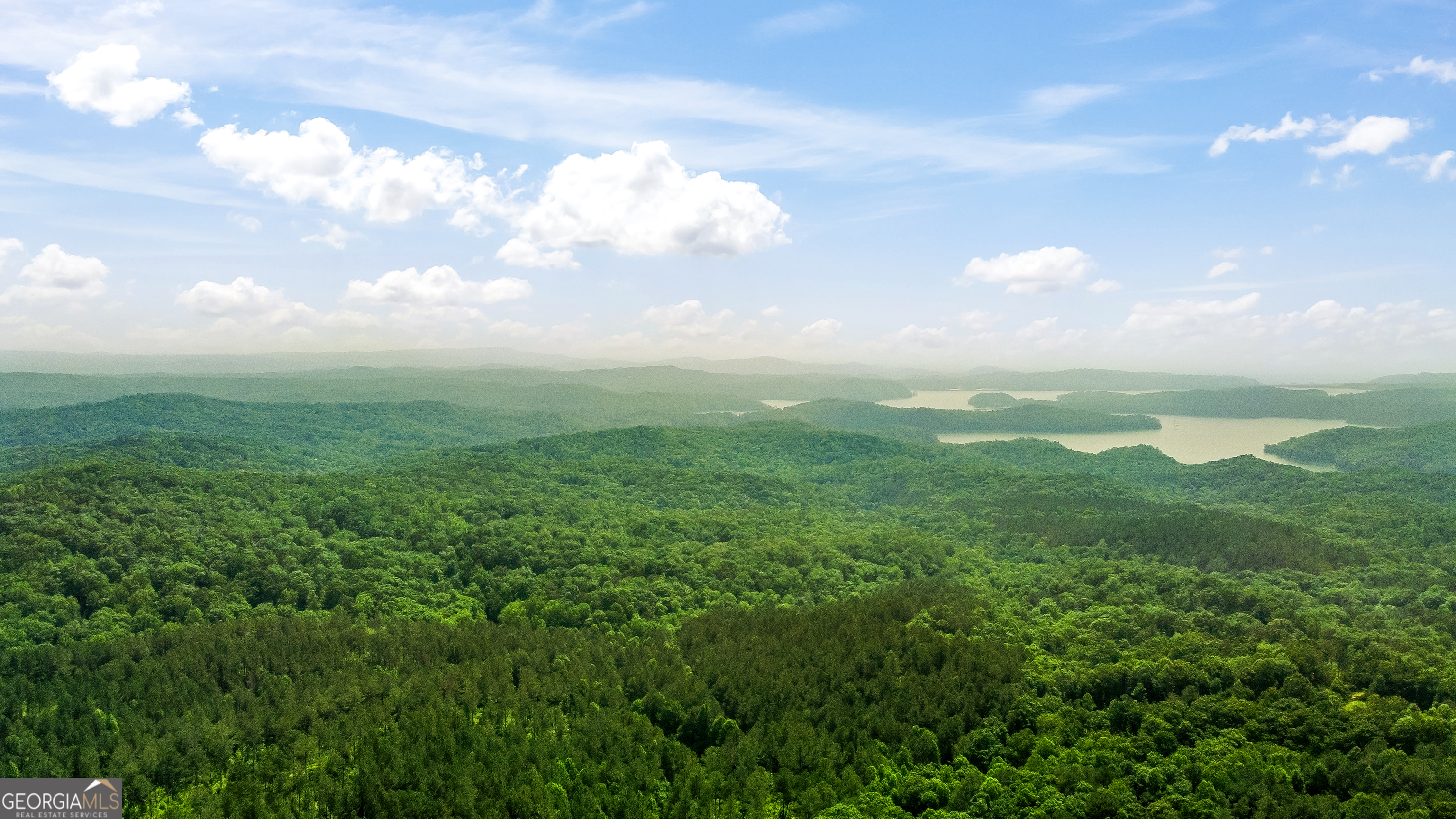 Unrestricted 31.2325 Acres with Power, LONG RANGE MOUNTAIN Views, and Multiple Building Sites - No HOA - Prime Location in Ellijay, GA Don't miss this rare opportunity to own 31.2325 pristine acres in the sought-after Oak Hill area of Ellijay, GA. Located directly to the left of 1207 Oak Hill Road, Ellijay, GA 30540, this exceptional property offers a mix of privacy, accessibility, and panoramic views-ideal for a private estate, family compound, or development. This unrestricted land with no HOA features power available at the road, excellent cell service, and multiple level to gently rolling building sites spread across two combined parcels: 26.19 acres from parcel 3024A 003 and 5.81 acres from parcel 3024 011Q, totaling approximately 32 acres. The property boasts long-range mountain views of both Fort Mountain and Grassy Mountain from various vantage points. It is located off a quiet county road, with all-paved access, yet less than 15 minutes to downtown Ellijay for dining, shopping, and recreation. The land has already been strategically cleared in key areas to open up the views, while maintaining a natural buffer of beautiful mature hardwood trees. Internal trails wind through the property for hiking, ATVs, or future driveway placements. There's also a small creek on the back left corner of the lot, adding to the serene natural setting. With ample road frontage and utilities nearby, accessibility is simple-just add a well and septic to begin building. Cell phone service is strong, and power is readily available at the road. This is a truly rare opportunity to enjoy peaceful mountain living with modern convenience and no restrictions. Driving Directions: From Walmart in Ellijay, take Hwy 515 South for 1.6 miles. Turn right on Hwy 382. At the roundabout, take the 2nd exit to stay on 382 and travel 5.3 miles. Turn right on Oak Hill Road. In 1.2 miles, the destination will be on the left, directly next to 1207 Oak Hill Road (new construction home). Sign in place. Use LandGlide to verify parcel lines and location. Coordinates for navigation: Map GPS to 1207 Oak Hill Road, Ellijay, GA 30540 - land for sale is immediately to the left of this address.