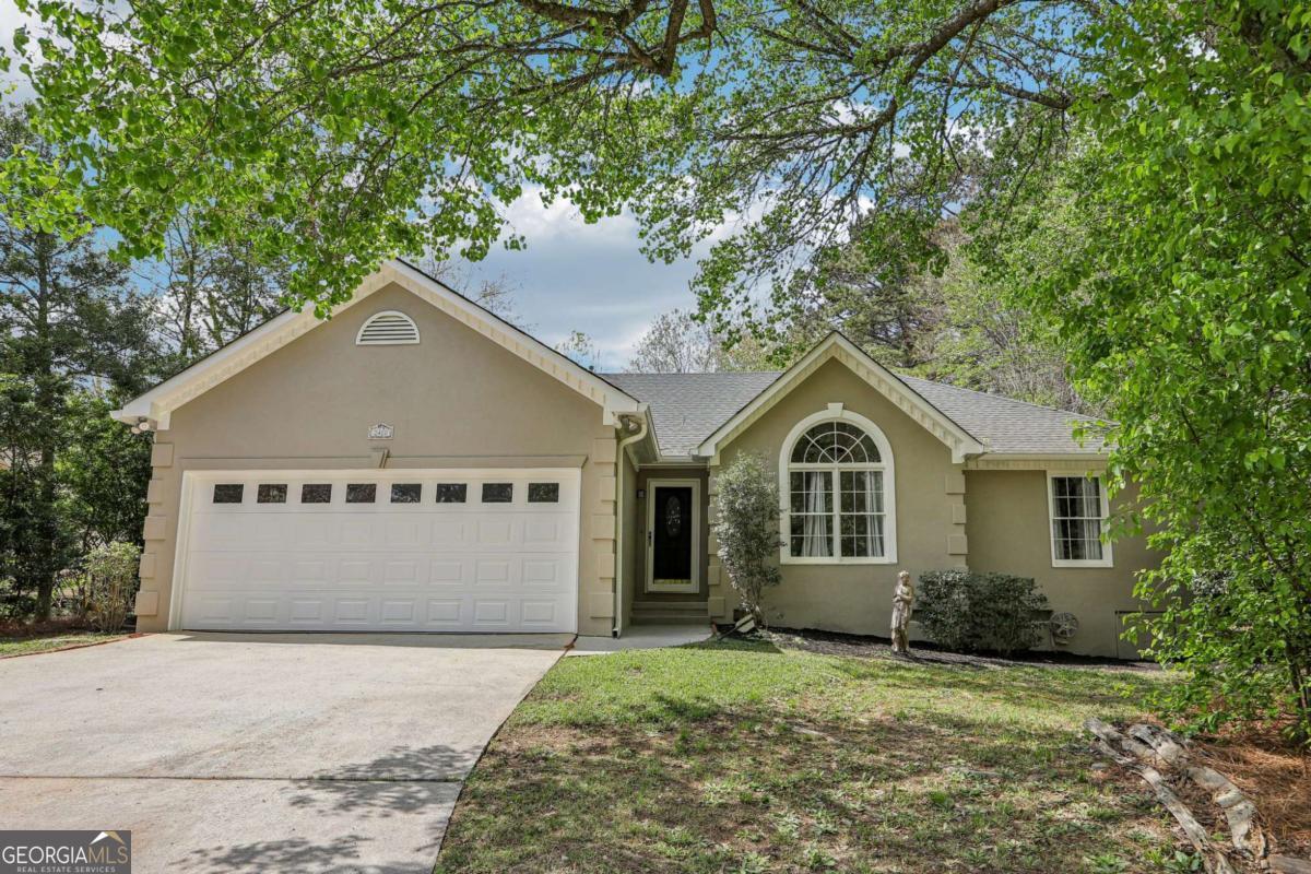 Dive into summer with this stunningly updated home featuring a sparkling pool! Step inside to gorgeous, easy-to-maintain LVP wood floors that flow throughout the living spaces. The inviting living room features soaring vaulted ceilings, a cozy fireplace, and an abundance of natural light. A breakfast bar leads to the beautifully updated kitchen, complete with solid surface countertops, shiplap accents, sleek white cabinetry, and elegant light fixtures. Enjoy poolside views from the bright and airy dining room, featuring a charming bay window. Retreat to the spacious primary suite with a sophisticated tray ceiling and a fully updated en-suite bath, offering dual vanities, a custom-tiled frameless glass shower, and stylish shiplap walls. Two additional spacious bedrooms and a full hall bath provide ample room for family or guests. Step outside to your own private backyard retreat! The fully fenced yard features a sparkling in-ground pool, a generous deck perfect for entertaining and grilling, and lush green spaceCoall backed by the serene privacy of mature trees. Just minutes away from the East-West Connector and Powder Springs Road, it, offers convenient access to a variety of restaurants, shopping, and entertainment options. Don't miss this incredible homeCoyour summer oasis awaits!