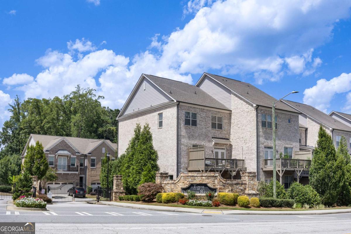 ***RARE PRIVATE END UNIT*** BE SURE TO WATCH THE STUNNING VIDEO TOURS*** Watch Braves Fireworks from Your Deck! This is where where location, lifestyle, and luxury collide! This stunning, impeccably maintained end-unit townhome offers the rare perk of watching fireworks from Truist Park right from your back deck. Inside, you'll find gleaming hardwood floors throughout with no carpet anywhere and a thoughtful three-story layout designed for comfort and entertaining. Speaking of entertaining, the centerpiece of the home, the kitchen, boasts a 8ft center island with gleaming quartz countertops, custom glass backspash, stainless steal applainces, 42 inch cabinetry with crown molding toppers, touch-less faucet, and upgraded hardware - all opening to the dining and living room! The terrace level is a true showstopper, with an open space perfect for hosting game days, movie nights, or casual gatherings. Hand crafted, oversized "drop zone" for coats and hats, built in Murphy bed (stays with home) that can convert to a guest suite + a full private bathroom. Bonus glass door leads to finished concrete patio under the deck, perfect for grilling and access to the largest yard in the neighborhood (thanks to being an end unit). Storage EVERYWHERE...huge closet and added storage space in the 2 car garage (not all townhomes have this feature). The primary suite is a true retreat, featuring a designer accent wall and a spa-like bathroom with an oversized frameless glass shower. Enjoy a lush, green lawn thanks to built in irrigation. Live steps away from the action and walk to The Battery, Braves games, and top dining spots like Superica, Yard House, and Punch Bowl Social. Catch a show at The Fox or explore the Chattahoochee River trails, all just minutes away. Easy access to I-75 and I-285 keeps the rest of Atlanta at your fingertips. This one checks all the boxes: location, upgrades, and unbeatable lifestyle. Don't miss it!