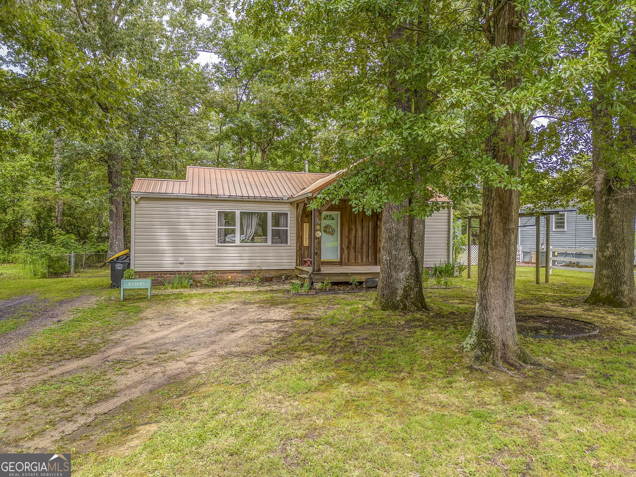 This cozy ranch-style retreat is nestled on a wooded lot just minutes from the shopping and dining conveniences of West Rome. A welcoming front porch sets the tone for this charming home, inviting you into a warm interior filled with natural light and rich wood flooring. The kitchen offers generous cabinet space and flows seamlessly into the main living area, creating a comfortable space for everyday living and entertaining. Bedrooms are thoughtfully positioned for privacy and comfort, offering a peaceful place to unwind. Step outside to enjoy a spacious fenced backyard surrounded by mature trees, ideal for relaxation or outdoor gatherings. A patio provides the perfect spot for morning coffee, while the outbuilding offers extra storage or space for hobbies. With its blend of character, functionality, and proximity to local amenities, this property is a true hidden gem.