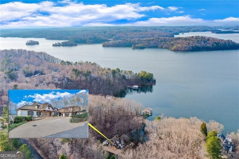 Prepare to be wowed by this Lake Lanier estate, never before on the market. This 1.9 acre property, nestled in a quiet cul-de-sac, presents a rare combination of expansive waterfront views, deep water, mountain views, a US Corp line close to the water and a location convenient to Atlanta via GA 400 and Gainesville. It's an easy walk to the deep water, double slip dock. The home's design, inspired by a French country home, features a classic open floor plan enriched with massive wooden beams, creating a warm and inviting ambiance. Built for entertaining, the main level great room is open to the kitchen and dining area and opens to a sunroom with incredible long range views. The loft with built-in bookshelves is a lovely escape as a reading room or library. You'll be everyone's favorite host with a terrace level that can easily host a huge crowd with its own kitchen, fireplace and screened porch. Don't miss the large bonus room/office that makes this the perfect place to work from home. With its own fireplace and lake views, you will never want to work outside the home again. The additional lake lot has its own deep water dock. Convenient not only to GA 400, but also to Gainesville, Northeast GA Medical Center and 985.