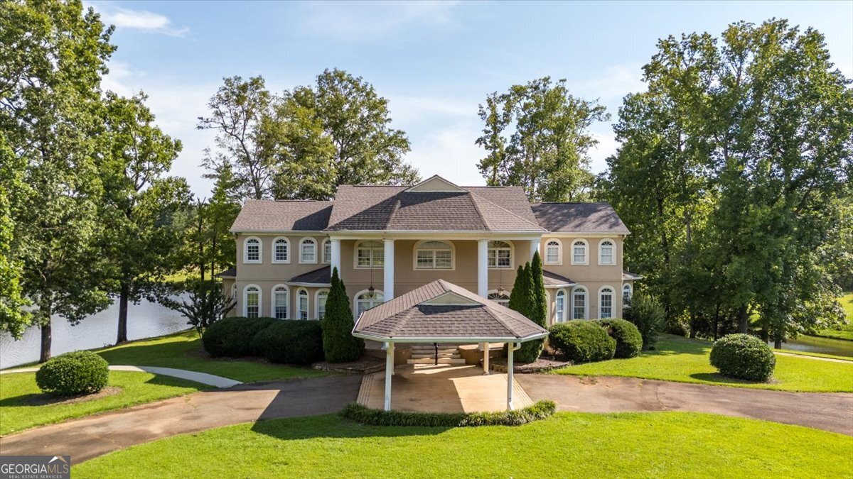 Stunning Custom Home with Breathtaking Lake Views on 8+ Acres Enjoy amazing views and ultimate privacy with this custom-built 4-bedroom, 3.5-bath home, perfectly positioned on over 8 acres overlooking a 22-acre recreational lake. This peaceful retreat offers a rare combination of elegance, comfort, and outdoor adventure. Inside, you'll find fresh paint and new carpet throughout. The main level features a spacious master suite complete with a cozy sitting area and two walk-in closets. The large kitchen includes a center island and flows seamlessly into the formal dining room, perfect for hosting. The formal living room/office offers flexibility for work or relaxation, and an upstairs loft/bonus room adds even more space for your needs. Step outside to enjoy the incredible setting-whether from the comfort of the back porch, the expansive yard, or the impressive two-story boathouse with two boat slips. Also included is a 3-car detached garage with an upstairs 2-bedroom, 2-bath apartment-perfect for guests, extended family, or rental income. If you're seeking tranquility, stunning lake views, and a lifestyle of recreation and relaxation, this property is truly one of a kind.