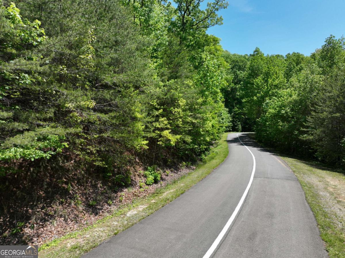 Private 3 acre lot in luxury gated mountain community. The terrain has 2 ridges that gives multiple building sites depending on what you are looking for. Build close to the road, or high in the back for bigger views! The way the terrain is shaped gives you lots of privacy no matter which location you choose to build. Approximately in the middle of the lot at the road front, you'll find a grassed area where you'll find an old logging road that ascends up to a flatter area you can use as one of the possible home sites. This path would make an excellent driveway! Continue higher up the mountain to obtain bigger views. You'll definitely feel like you are living in the treetops. Okay to buy now and build later. Underground electric, cable, internet, and phone already in place, and being close to the back gate will make it a breeze for your builder! Approx 20 minute drive to Ellijay, and 25 minutes to Jasper. You'll feel like you're in a state park in the beautiful upscale community of Georgian Highlands. Gated, HOA, 2000 min, no rentals, all buyers must be with an agent per HOA. Terrain parcel line photos are an approximation only.