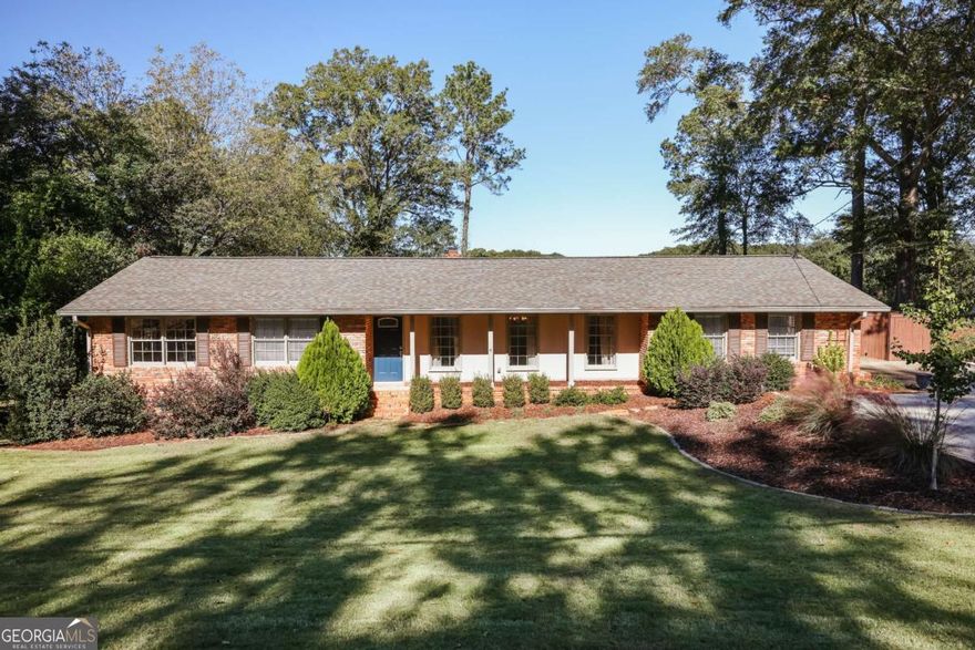 Charming brick ranch in the heart of Five Points on a large, private lot with fenced backyard and new Trex deck ideal for outdoor grilling and entertaining. Inside, hardwood floors lead to a renovated gourmet kitchen with gas range, hard surface counters, and views into a spacious keeping room. A sunroom provides additional light-filled living space. The primary suite includes a large bedroom, double vanity, and tiled shower. Two additional bedrooms, including one oversized room perfect for a guest suite with sitting area. The guest bath has been updated with a garden tub and designer selections. Enjoy a full laundry room, large family room with fireplace, and easy one-level living just minutes from Five Points dining and UGA. This warm and inviting home offers a rare combination of privacy and charm.