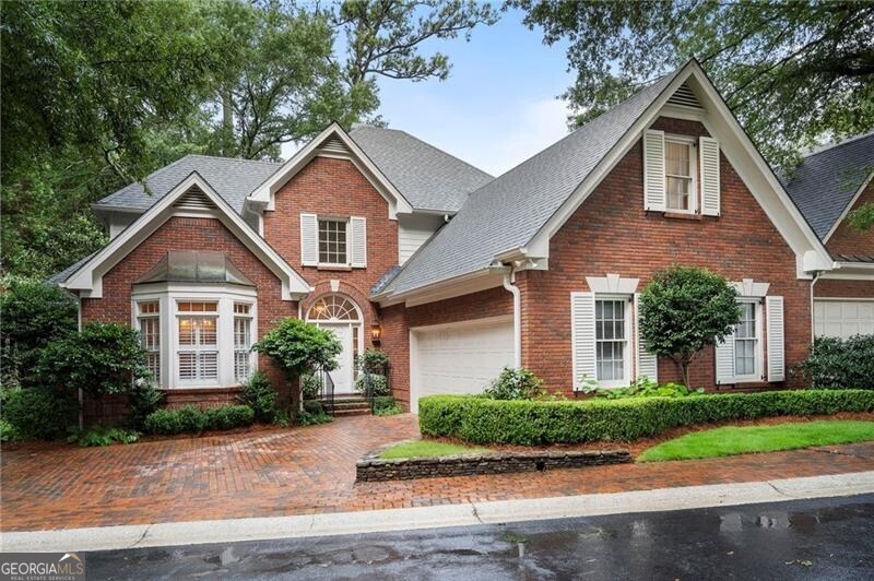 Tucked into an charming 18-home community surrounding a beautifully landscaped private park, this custom-built brick home blends timeless architecture with thoughtful, high-end updates. An inviting foyer opens to the bay-windowed dining room with a deep tray ceiling, leading into the sun-filled two-story great room, where a fireplace is flanked by a dramatic wall of windows overlooks the private backyard. The kitchen features marble countertops, a Wolf range, a Miele oven, and a vaulted fireside keeping room with additional built-ins-perfect for casual meals or cozy mornings. French doors open to an expansive back deck, ideal for entertaining. The main-level primary suite includes a custom walk-in closet and a beautifully renovated bath with marble finishes, double vanities, a large walk-in shower, and a soaking tub. A powder room and a laundry/mudroom-conveniently located just off the two-car garage-complete the main level. Upstairs you'll find two spacious guest bedrooms, a shared bath, a large storage closet lined with shelving, plus a cedar closet. An additional office was added upstairs, providing a dedicated work-from-home space. The fully finished daylight terrace level offers incredible flexibility with a bedroom and ensuite bath, a wet bar, an additional living room, a bonus room, and a workout room. French doors lead out to a covered bluestone patio and a fully fenced, gated yard that has been newly turfed for easy maintenance. Additional upgrades include a new roof (2022), two new AC units, $20,000 in exterior landscape lighting, a working well-water irrigation system for both front and back yards, and designer lighting throughout, including selections from Visual Comfort and Currey & Co. In an incredible Buckhead location close to top schools, shops and more, you don't want to miss this one!