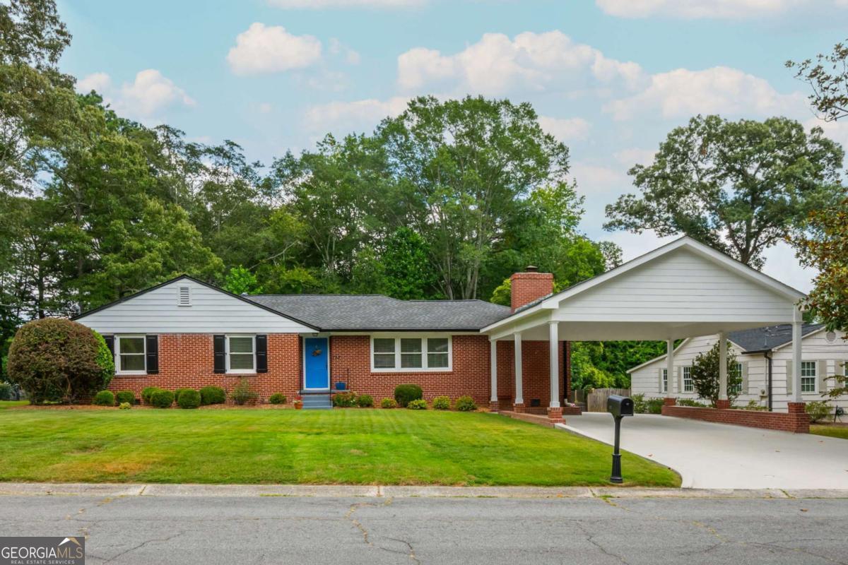 Welcome to the brick ranch beauty you've been waiting for-nestled in the heart of West Side Elementary district and just 1.3 miles from the iconic Marietta Square! Whether you're a savvy first-time buyer, a downsizing empty nester, or somewhere in between, this 4-side brick gem is the total package. Freshly painted inside and out (yes, even those kitchen cabinets got a glow-up!), this home is bursting with charm. You'll love the original hardwood floors, and prepare to be wowed by the 2022 primary suite addition-hello, huge bedroom, walk-in closet, double vanities, separate tub, and oversized shower that feels straight out of a boutique hotel. Need flex space? The fireside bonus room is perfect for a home office, playroom, or cozy second living area. With FOUR bedrooms and 3 renovated baths, everyone gets their space. Bonus points for the energy-efficient windows, 2-car carport, replaced driveway, 3-year-old HVAC, and 8-year-old roof-all the expensive stuff is already done. Outside, enjoy a spacious flat backyard perfect for kicking a soccer ball, planting a garden, or hosting a BBQ. The outbuilding makes a great spot to stash your lawn gear or start your dream workshop. And let's talk location: in just 6 minutes (or a scenic 30-minute walk), you're at Marietta Square grabbing dinner, a latte, or catching a concert. This is small-town charm with all the modern perks. Don't miss your chance to own this timeless ranch in one of Marietta's most coveted spots-schedule your tour today before someone else beats you to it!