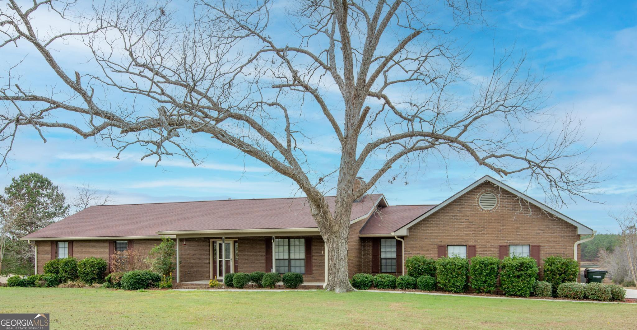 Brick home situated on 10 acres of land, some cleared and some with trees. Brand new roof with 50 year warranty installed February 2025. Beautiful views of the shared pond from the back porch and tiered deck on back of home. Pond is shared with 3 neighbors and has a dock. There is a 3-car attached garage and an additional detached 3 bay workshop with office and half bath. Walk inside the front door to a family room featuring a beautiful masonry fireplace with electric insert. The large kitchen has a dining area, island and plenty of windows that face the pond, pantry and additional pantry space in the mud room. Separate office is located near off the kitchen area. The Primary bedroom features his and hers walk in closets and a separate tiled shower and double vanities with a walk-in whirlpool handicap accessible bathtub. Current owner has updated bathrooms and made other improvements.