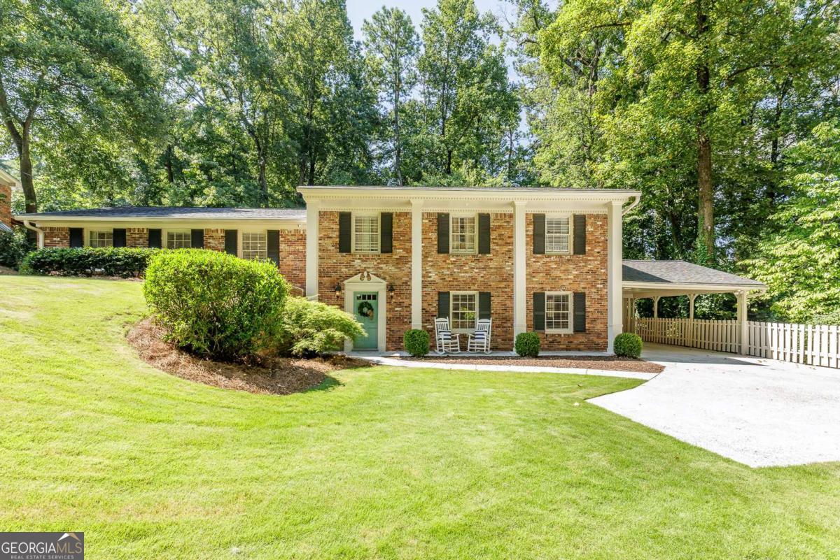 This charming 4-sided brick home in a popular neighborhood and top-rated Dunwoody Elementary is move-in ready and features a spacious, open-concept layout with a beautifully renovated and expanded kitchen that flows into a vaulted great room and dining area. Exposed beams and large windows bring in tons of natural light and offer views of the picturesque private backyard. The kitchen is truly the heart of the home-thoughtfully redesigned with an oversized island, crisp white cabinetry, built-in pantry, farmhouse sink, double ovens, and a beverage cooler, making it ideal for cooking, gathering, and entertaining! Walkout from the great room to a peaceful patio and flat landscaped backyard surrounded by trees providing total privacy - perfect for play, relaxing, or hosting guests. Upstairs you'll find three bedrooms with hardwood flooring and updated baths. The daylight basement adds even more flexible space with a large entertainment room, additional bedroom, half bath, and plenty of storage. Located on a quiet, non-cut-through street with access to the Dunwoody Trailway, this home is just minutes from parks, shopping, dining, and easy access to I-285 and GA-400. Other upgrades include a new sewer line, 50 gallon water heater, added insulation and storage shed. This is a wonderful, active community and a great find!