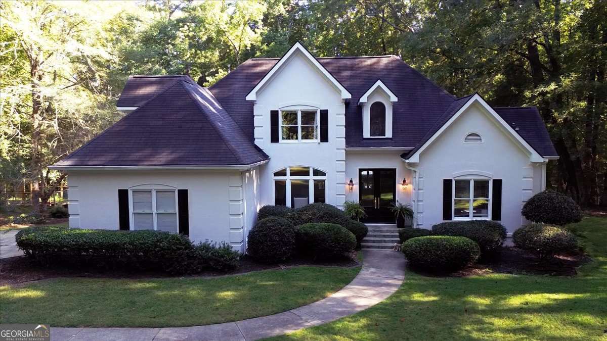 Welcome to timeless elegance and modern comfort in the prestigious Hodgsons Place neighborhood. This stunning home is located on 4 acres of land and offers 4 spacious bedrooms and 4 bathrooms, providing ample space for family, guests, and work-from-home flexibility. Step inside to discover the warmth of hardwood floors that flow seamlessly throughout the main level with 10 foot ceilings. Retreat to the luxurious primary suite on the main level with an en-suite bathroom that was newly renovated this summer, featuring double vanities, a freestanding tub, tiled walk-in shower, and an expansive closet. The kitchen and main living areas have been recently renovated with white marbled quartz countertops, custom cabinetry, and all KitchenAid appliances. The formal dining area features large windows with ample natural light while custom wainscoting throughout adds a luxurious feel to the space. From the living area, double doors lead to a back deck-the perfect spot to unwind on the custom built-in benches while enjoying the view of the sprawling backyard, set on just over 4 acres of land. Upstairs, youll find three generously sized bedrooms. One has a custom built-in window seat with a private updated full bath, while the other two share a hallway bathroom, complete with a gorgeous new tile floor, perfect for kids or guests. This highly sought after neighborhood is private and spacious, yet conveniently located just minutes away from downtown Athens, UGA, and Athens Country Club.