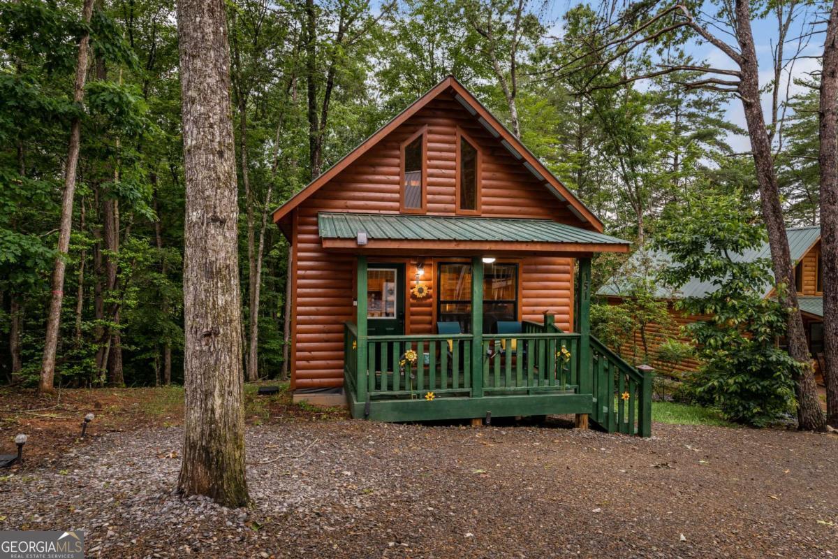 Escape to the mountains in this beautifully crafted tiny log cabin, nestled in the serene woods of Murphy, North Carolina. Offering the perfect blend of rustic charm and modern convenience, this cabin features paved road access for easy year-round entry, making it an ideal getaway or income-producing vacation rental. Step inside to an open-concept floor plan that maximizes space and comfort. The living area flows seamlessly into a well-appointed kitchen with granite countertops, custom cabinetry, and all the essentials for cozy mountain living. A charming loft space adds extra sleeping or storage options, making this home as practical as it is picturesque. Sold fully furnished, this turnkey retreat is ready for immediate enjoyment-just bring your suitcase and start living your mountain dream. Whether you're looking for a peaceful escape, a weekend getaway, or a unique investment opportunity, this cabin has it all. Don't miss your chance to own a slice of paradise in the heart of the Appalachians!