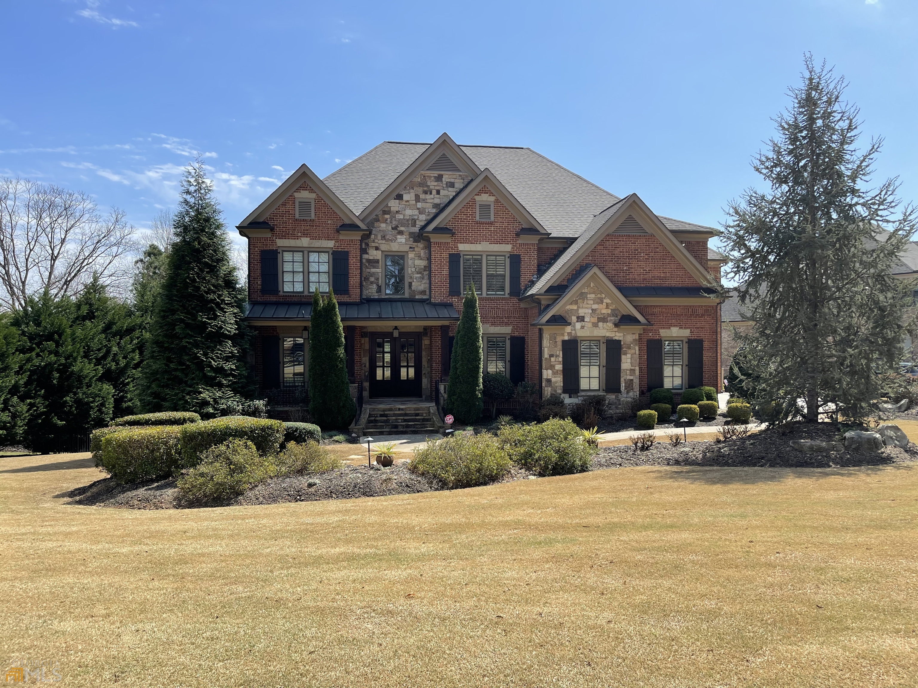 Spectacular lakefront home in Greystone Manor, a gated community in one of the area's top school districts. From the timeless brick & stone exterior, to the expansive backyard overlooking the lake, there is so much to love about this pristine home full of custom finishes. The lighting fixtures alone will take your breath away! Highlights include the stunning great room with coffered ceiling and cozy keeping room with gorgeous stone fireplace. Modern kitchen with all of the latest finishes. Finished terrace level. 6 fireplaces.