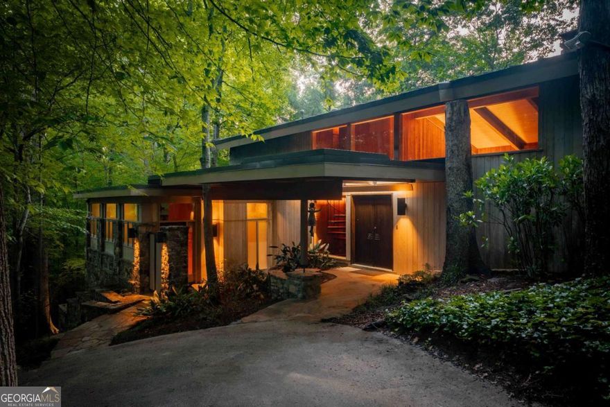 Welcome to THE FALLS. A period correct mid-century modern masterpiece overlooking a 120 FOOT CASCADING WATERFALL! Honoring timeless design while embracing progressive innovation & celebrating nature as a lifestyle this home is an absolute one of one. Designed by renowned Atlanta architect Herbert Millkey, the home is a showcase of natural materials and meticulous craftsmanship-from hand-selected stone to wormy chestnut paneling milled from a single, historic tree. Every element inside reflects a commitment to organic architecture, with walls of glass that dissolve the boundaries between structure and setting, and private balconies extending from every bedroom overlooking the dramatic, ever-present cascading WATERFALL that flows just beneath the edge of the home. Spanning three unique levels, the home is designed for flexibility and generational living, including an award-winning "age-in-place" addition that functions as a fourth bedroom, private studio, or guest retreat. The interiors flow seamlessly, anchored by a recently updated kitchen connected by sight lines that always lead back to THE FALLS. A spa-like primary suite boasts a Japanese-inspired garden and bath, creating a personal retreat that feels rooted in calm and balance. Four bedrooms. Three baths. Multiple living spaces. Perfect balance. Throughout the home, there's a constant sense of movement and stillness-of water, wood, and stone working together in quiet harmony. Expansive outdoor living spaces are thoughtfully designed for year-round enjoyment overlooking almost 4 acres of preserved nature and a climax Piedmont Forest that is literally in the heart of the city. There is over a mile of non-contiguous walking trails, bridges, & sitting areas spread across the property. Fed by the headwaters of Peavine Creek that stretches over 500 feet in length across the property, the WATERFALL itself spans 100 foot in width, 120 foot in cascading length, & has an island in the middle of it's two outpourings flooding the home with ever present sounds & visuals of wonder & beauty. The striking & distinctive nature of this matchless home provides a once in a lifetime opportunity to live in the center of nature while also living in the center of everything. Just 6 blocks from Emory Village & the CDC plus Less than a mile to Downtown Decatur & Druid Hills Golf Club! An unprecedented chance to escape the city while still living in the center of it! THE FALLS is not just a home, but a living experience-where architecture doesn't sit on the land, it becomes part of the home's illustrious story...where nature comes first. BRILLIANT!