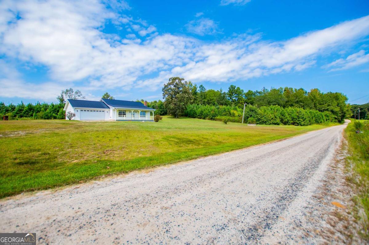 Country living at its finest with the convenience of a stepless and low maintenance ranch. Situated on 4.2 gorgeous acres, this vinyl sided ranch offers the outdoor space you desire along with a well appointed and easy to care for home. Open concept kitchen and den, attached garage, covered front porch, and enclosed back sunroom. No carpet here either! You've also got a metal roof, wood burning fireplace, double paned vinyl windows, stylish fixtures, loads of storage, pull down attic access, and a gorgeous tiled shower.