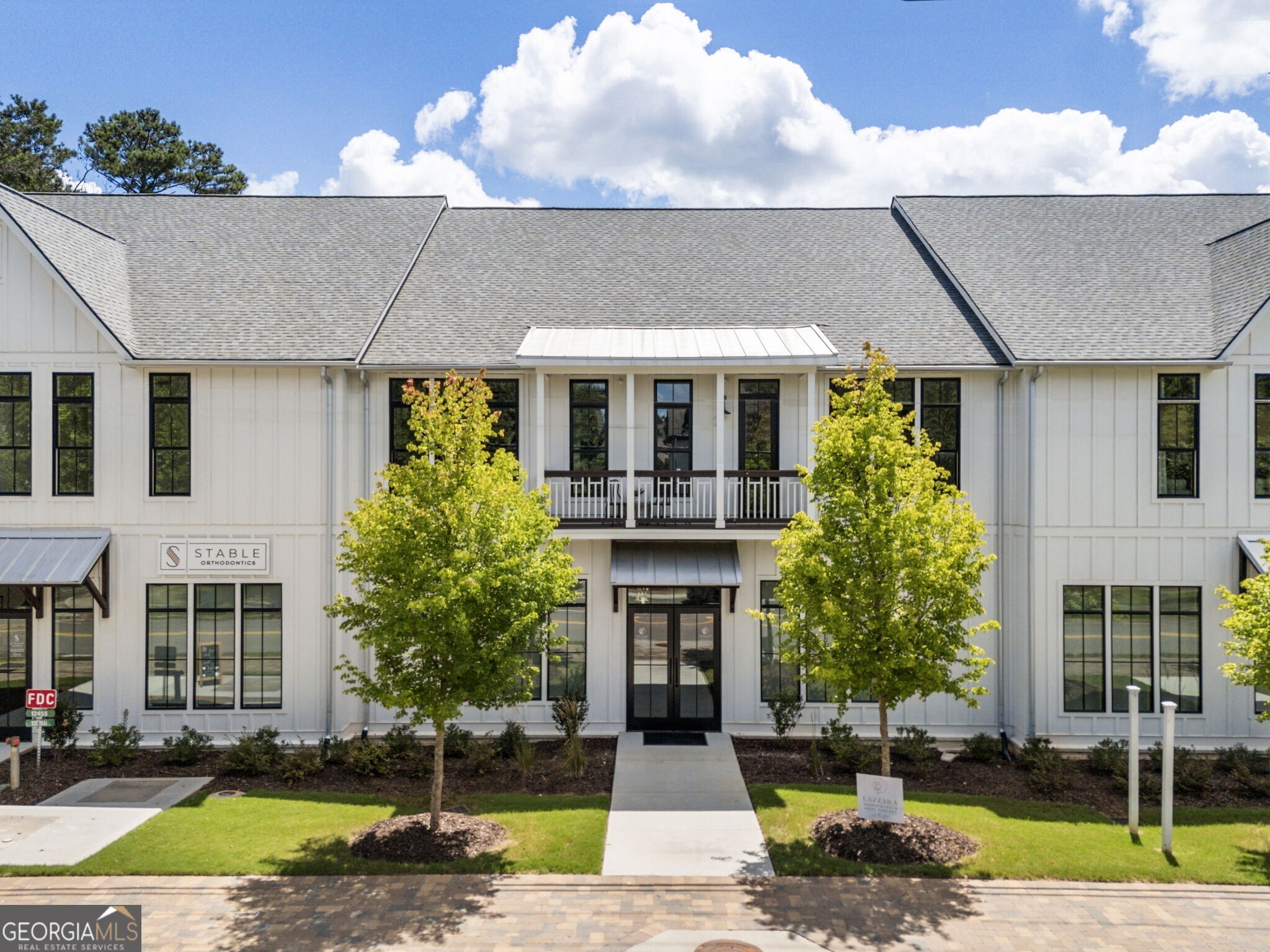 Seller is offering a $15,000 buyer concession to be used for closing costs or mortgage rate buy down with an acceptable offer. Experience convenience and low-maintenance living combined with an open floorplan in the heart of the Crabapple Market district just steps away from Milton High School. The vibrant area of Crabapple boasts local restaurants, shopping, community farmers markets and more. Now ready for move-in, these brand-new condos at Milton Pointe at Broadwell offer the perfect "lock and leave" lifestyle for those seeking convenience, luxury, and style. Step outside and immediately enjoy charming shops, gourmet dining, and the picturesque town green of historic Crabapple. Recognized repeatedly on national "Best Of" lists, the City of Milton is celebrated for its safety, uncrowded ambiance, top-tier schools, and friendly community atmosphere. This stunning 2-bedroom, 2.5-bathroom condo showcases modern design and thoughtful details, including a gourmet kitchen with a large island with quartz countertops, lots of cabinetry, and stainless steel appliances. The spacious primary suite features a luxurious ensuite bathroom and a walk-in closet with built-in shelving, while the secondary bedroom located away from the primary offers privacy, large closets, and a beautiful full bathroom. Bright, open living spaces include a cozy family room with a fireplace and a dynamic feature wall leading to an incredible covered outdoor living area that is perfect for entertaining or relaxing outdoors. Additional highlights include a private tandem 2-car garage, large storage unit, tankless water heater, and ample closet space throughout the home. Don't miss your chance to embrace Milton and be close to GA 400, restaurants, downtown Alpharetta and Avalon without being on top of any of the noise or crowds. Schedule your visit today and make this exceptional condo your own!