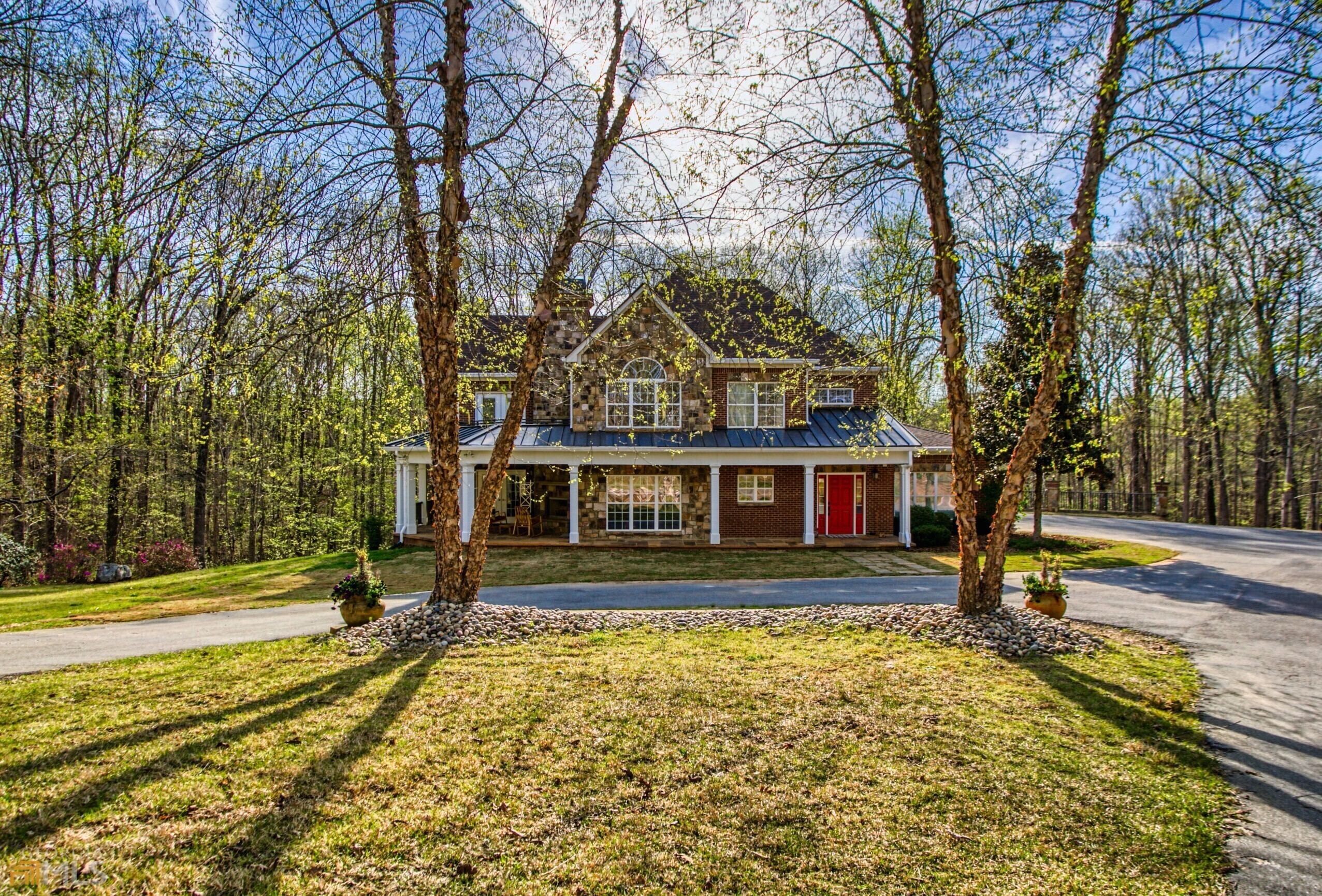 Come fall in love with this beautiful custom built home on 5.09 acres with lots of outdoor areas to enjoy the views! As you drive through the front gate, you will enjoy the scenery and come to a circular driveway in front of the home. On the side, there is a three car garage and the front of the home has a covered porch that wraps around to the other side with an outdoor stone fireplace. Upon entering, you will start to see stone accents throughout. The kitchen, with a walk in pantry, and dining area are very open and there is a second stone fireplace in the family room. There is a full bed and bath on the main level with a screened porch just outside. One of two laundry areas is also on the main level. There is also a fireplace in the large owner's suite on the second level with a spacious bath and walk in closet and an additional laundry area. Additionally, on the second level you will find a loft area with a large palladium window and exposed beams, plus another bedroom and full bath. The basement is finished and includes a bed and full bath, media room and bar area perfect for entertaining. Outside is another covered porch and terraced area with a fire pit that overlooks the backyard just waiting for a pool to be added. Great shopping and park areas nearby! Elementary school is minutes away.