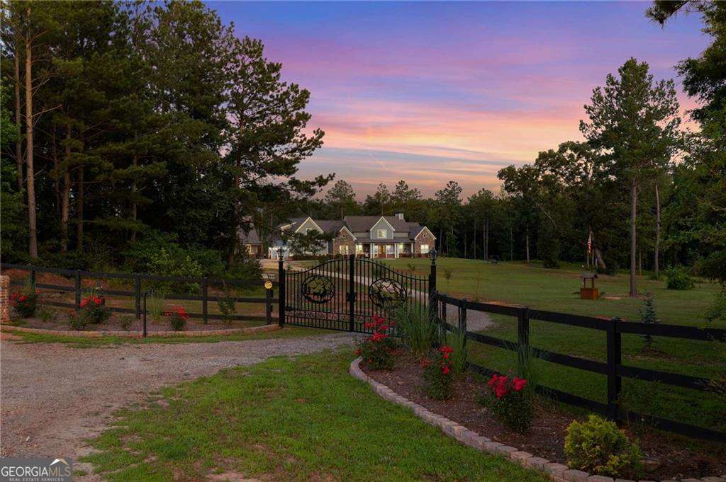 This stunning home is back on the market due to no fault of the sellers - this is your second chance to make it yours! Have you been looking for the perfect family compound? Look no further than this 27 acre, beautiful property that you could build multiple homes on or enjoy all the acreage to yourself. This gated, '22 custom built, craftsman style home with a 3 car garage is thoughtfully designed with all the living space on the main floor that features 2 master suites with oversized en-suites, screened in porch with a wood burning fire place and views to the heated, salt water pool and the 2,400 sq ft guest house with an additional 2 car garage with 12' ceilings and amazing views! The guest house also has a heated and cooled space for your fur babies with outside/inside access. Enjoy the open concept layout that connects to a beautiful kitchen - featuring cabinets that reach to the ceiling, leathered granite countertops, pot filler, wifi stainless steel appliances, including a double oven and an extra large island perfect for entertaining. Special features throughout include a built in speaker system for both homes, beautiful hardwood floors, laundry that connects to the master closet, an upstairs bonus room with a full bath, and energy-efficient amenities, including foam insulation, 2 soft water heaters and two septic systems. (The home is pre-wired for a Generac system.) What an exceptional retreat combining luxury, functionality, and natural beauty. Whether you're hosting gatherings, relaxing poolside, or enjoying the surrounding scenery, this is a home and land you'll never want to leave. Schedule your private tour today to experience this one-of-a-kind property.