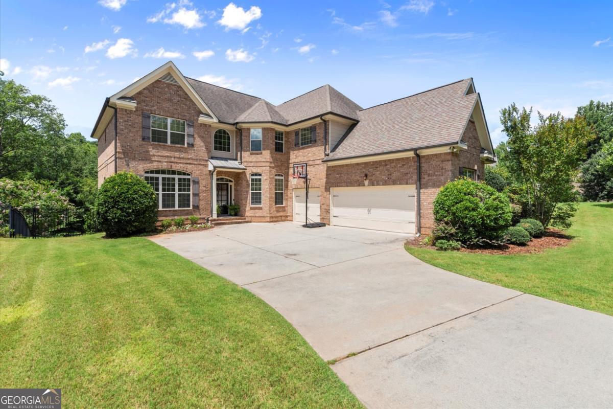 Absolutely phenomenal executive home in the highly sought-after Pope High School district, nestled within a quiet boutique neighborhood on a beautifully landscaped 3/4-acre lot. Enjoy complete privacy and a spacious backyard with plenty of flat lawn - perfect for outdoor fun, pets, or future pool plans. This impeccably maintained home blends timeless style with everyday functionality. At its heart is a bright, open-concept kitchen featuring a large center island, walk-in pantry, and effortless flow into the living space - perfect for entertaining and family life. A stunning double-sided stone fireplace anchors both living areas, creating warmth and character throughout the main level. Additional main-floor highlights include rich hardwood floors, abundant natural light, a dedicated home office, and a stylish dining room. A guest suite on the main level adds flexibility for visitors or multigenerational living. Upstairs, the spacious primary suite offers a serene retreat with a cozy sitting area, spa-like bathroom with walk-in shower and soaking tub, and an oversized walk-in closet. Three additional bedrooms include one en-suite and a Jack-and-Jill, each with generous closet space. A large media or bonus room provides the perfect space for movie nights, a playroom, or homework zone. Brand new carpet was just installed throughout the upper level. Step outside to enjoy the peaceful screened-in porch, grilling deck, and lower-level patio - all overlooking a fully fenced, flat backyard oasis. A spacious 3-car garage completes this exceptional property.