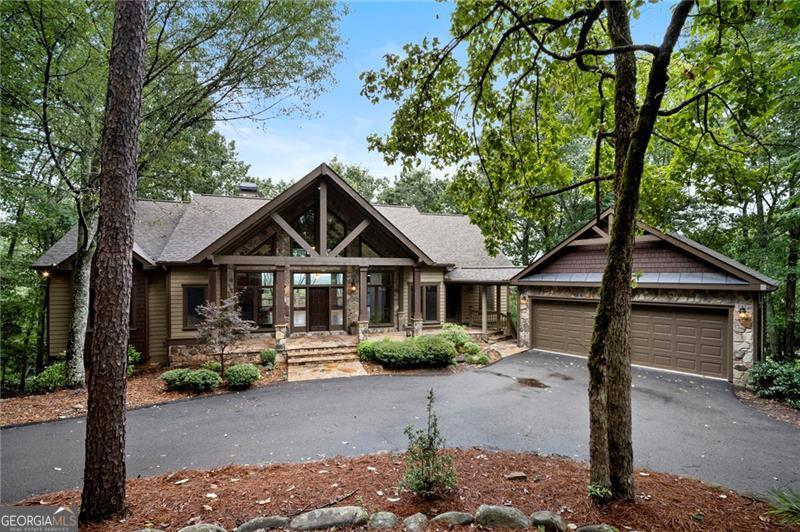 Well appointed 4 BR & 3.5 BATH design Executive home with an expansive open floorplan located on top of Summit with panoramic long range mountain views from every vantage point. Hardwood floors throughout the main level, high volume ceilings with exposed wood beams and stacked stone fireplace from floor to ceiling, built-in cabinets, and the back wall is home to a wall of windows with views from every vantage point. Cathedral ceiling with T&G wood in the kitchen and dining area, plus a keeping room /study with large picture windows on 3 sides of this space to enjoy long range views from as an added bonus. Oversize gourmet kitchen with stainless steel appliances, solid wood cabinets, quartz countertops, work island and breakfast nook area. Oversize Master BR suite with double trey ceiling, hardwood floors and large picture windows, and the expansive master bath is equipped with a steam shower and separate walk-in jacuzzi tub, plus custom built-in shelving in the master closet. On the terrace level there are two additional bedroom enclave suites, a large family room with stacked stone fireplace, large built-in bar with kitchenette ideal for entertaining, and a custom-built wine cellar that cost over $50,000 to complete. In addition, the movie room downstairs was originally the 4th bedroom, but can easily be converted back into additional sleeping quarters if needed. Pella windows throughout, flagstone covered front porch, EZ Breeze enclosed porch and expansive deck area with maintenance free Trex boards on the main and covered deck on the terrace level. A circular driveway for easy access, centrally located within the community with close proximity to the amenities, and located just 5 minutes to the North Gate for quick ingress and egress. This special one of a kind home delivers rustic elegance throughout. A must see!