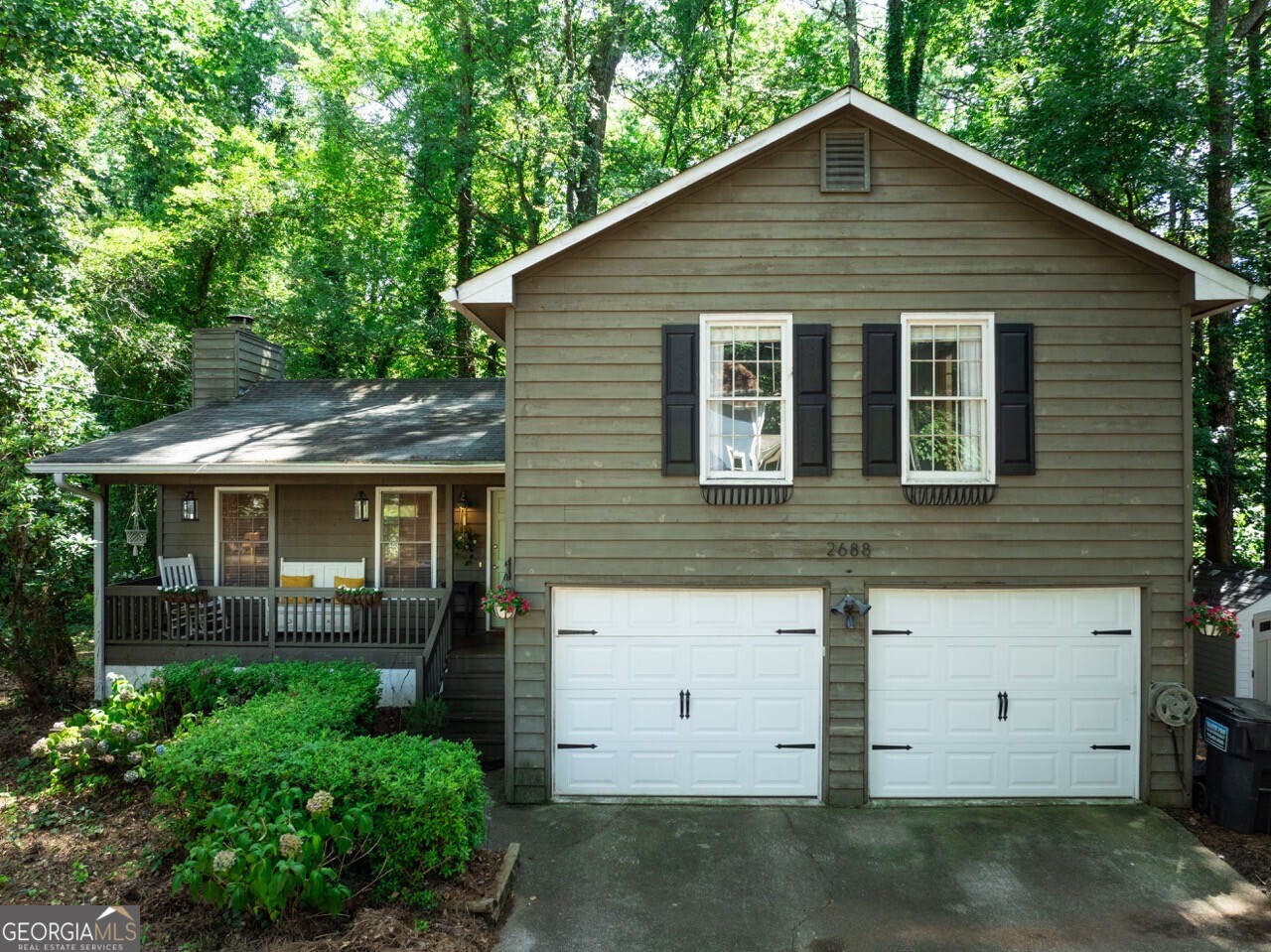 This is it! From front porch sitting to back deck living, this home has it all! The vaulted living room boasts a floor-to-ceiling stone fireplace, with beautiful original hardwoods. Natural light pours into this spacious living area, with fresh paint & modern light fixtures. The updated kitchen includes quartz countertops, solid-wood custom shelves, stainless steel appliances, a large, sparkling porcelain sink & an abundance of cabinet storage. Step out of the dining space onto a private, covered patio - with a brand new deck! Enjoy a serene, wooded retreat, as you sit beneath the tin roof and sip your coffee. Venture upstairs to find solid, white oak custom flooring in the hallway and all three bedrooms. Discover the oversized primary bedroom with two large closets, en suite with a bathtub, and bright windows that flood in the sunlight. Sit on the front porch and you'll soon see neighbors, constantly out walking in this quiet & peaceful community. Other features include a new HVAC system, an expansive 2-car garage complete with cabinets & shelving, and a storage shed on the side of the house. Located less than 10 minutes from both Downtown Duluth & Historic Norcross, a new adventure is always nearby! Nestled toward the middle of the neighborhood, this home feels tucked away, though just a few minutes from grocery stores, restaurants & more. Convenience, coziness, character & charm. This treasure of a property is move-in ready, only waiting for you... Welcome home!
