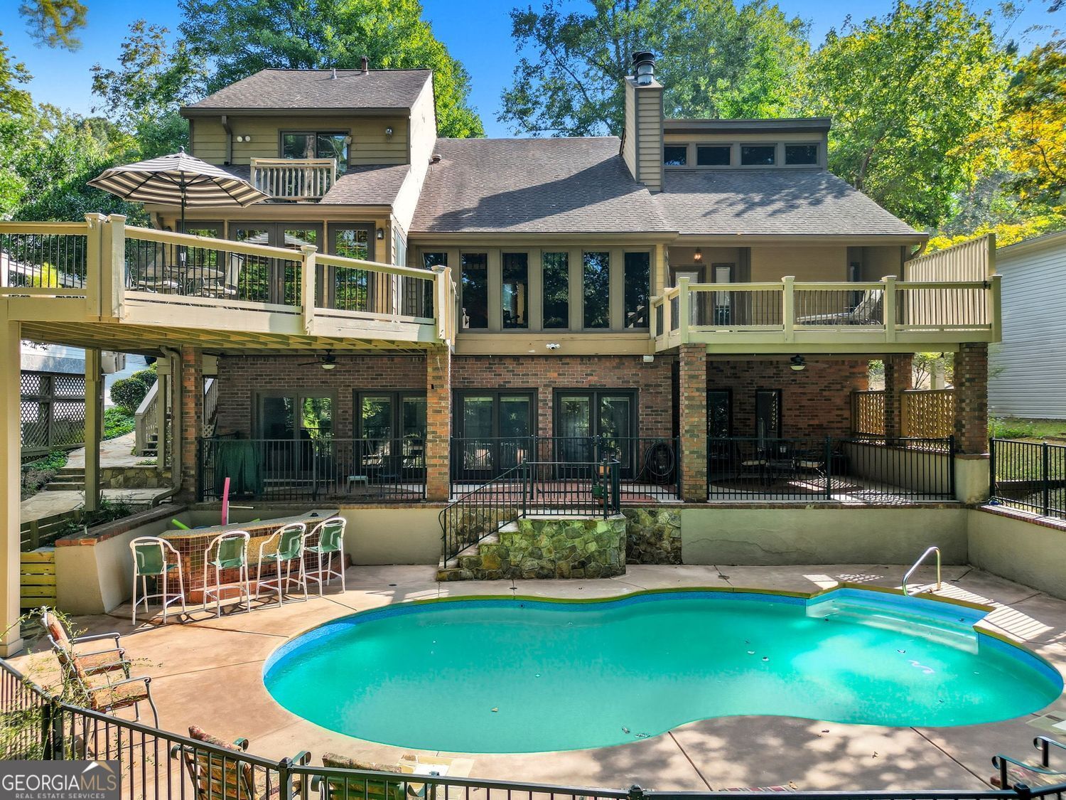 Looking for a lake view from almost every room? Conveniently located near shopping, restaurants, and 5 minutes from GA 400. 5 BR, 4.5 BA, Finished Basement, Pool, and 30x30 2-slip/2-story. DEEP water, PRIVATE party dock. 3 fireplaces. Primary Suite on the main with doors to the deck and a flagstone fireplace. The two-story family room features a tongue-and-groove ceiling with beams and a wall of windows overlooking the pool and lake view. Floor-to-ceiling flagstone fireplace. Top-rated schools. Fall in love with the heart of the home: the kitchen you've been waiting for. Open, bright, and thoughtfully designed, this chef's kitchen overlooks the dining room. It's truly the kitchen of your dreams-perfect for cooking, entertaining, and gathering with family and friends. The main floor features a spacious vaulted ceiling master suite, complete with a walk-in shower and soaking tub. Upstairs, you'll find two additional bedrooms and one full bathroom. A finished basement offers a versatile blend of functional living space with a kitchen, living area, pool table, 2 bedrooms, and two bathrooms. Step outside to your private pool and a beautifully landscaped backyard. An expansive flagstone patio and multiple decks are perfect for entertaining. A covered eating area and custom stone details make this the perfect space for entertaining or relaxing. The gentle walk to the lake under mature trees provides both privacy and a serene natural setting. This home isn't just a place to live-it's a lifestyle. The garage offers a walk-up attic for storage.