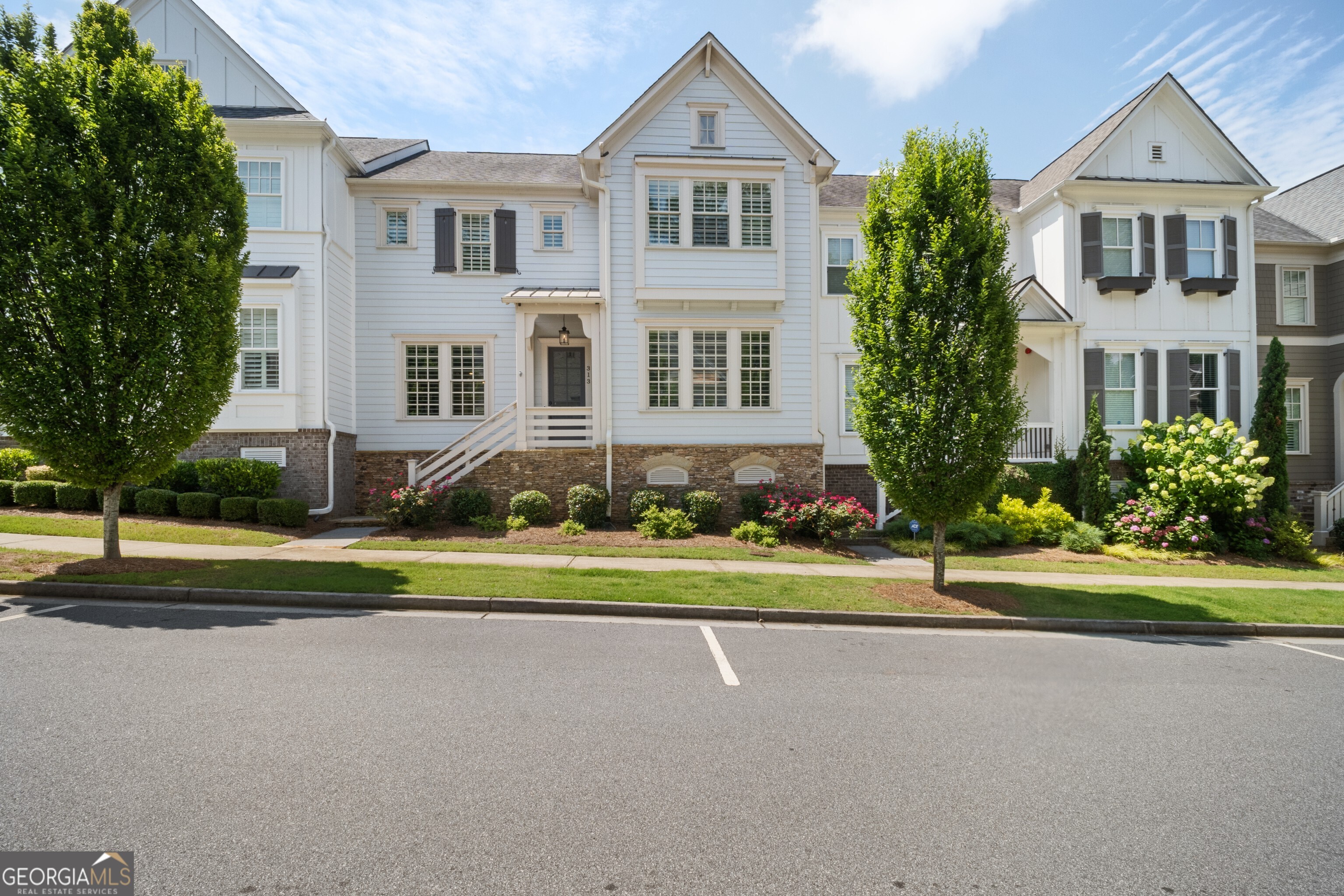 This stunning townhome is a rare rental opportunity in the sought-after South on Main community, offering high-end custom upgrades and designer details throughout. From the moment you walk in, you'll notice the thoughtful craftsmanship like the custom shiplap accent wall in the family room and the elegant wallpaper and vertical shiplap in the dining area that elevate the entire space. The chef's kitchen is both functional and fabulous, featuring a large island with quartz countertops, expanded cabinetry, and a custom appliance garage with built-in outlets plus a wine fridge for easy entertaining. Designer brass pendants add the perfect glow to your gatherings. Upstairs, the primary suite is your personal sanctuary, complete with a custom feature wall and a spa-inspired bathroom that makes every day feel like a retreat. The secondary bedrooms are generously sized and ideal for guests, home office space, or whatever suits your lifestyle. Additional perks include Gladiator overhead storage in the garage and professional Visiv landscape lighting that enhances curb appeal from day to night. As a resident of South on Main, you'll enjoy access to resort-style amenities: a 6,000 sq. ft. clubhouse, state-of-the-art fitness center, pool, amphitheater, pavilion, dog parks, playground, community garden, and fire pits for those cozy evenings with friends. Best of all, you're just a short walk from the vibrant downtown Woodstock scene with restaurants, breweries, live music, yoga studios, and more are right at your doorstep.