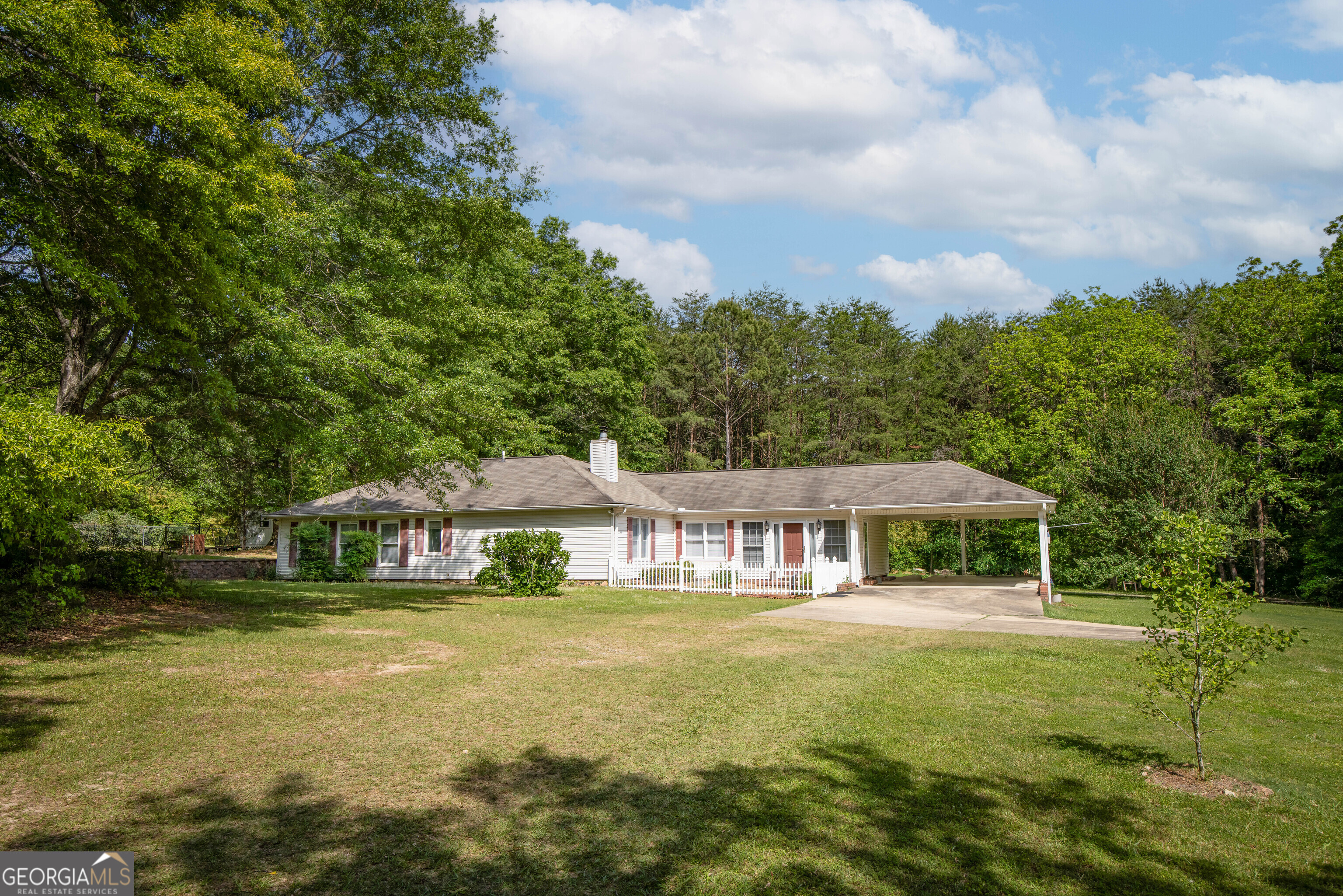 Come home to 22 acres of country living at its finest in Harris County! This spacious 4-bedroom, 3-bathroom home is nestled on a breathtaking piece of land. The well-maintained home has many self-sufficient features including a backup generator and two wells. Four storage/outbuildings, two of which are wired, offer ample space for your tools and equipment. Explore the walking trail around the property and enjoy the serenity of the surrounding landscape. Inside, the home offers a spacious and inviting layout, perfect for family gatherings and entertaining. Features like the built-in bookcase, built-in cabinet, and tool cabinet in the carport add practicality and charm. The property includes six blueberry bushes, a fenced garden or pet area, three attics for storage, and an electrical port in the yard. With its beautiful land, trees, and home, this property has it all!