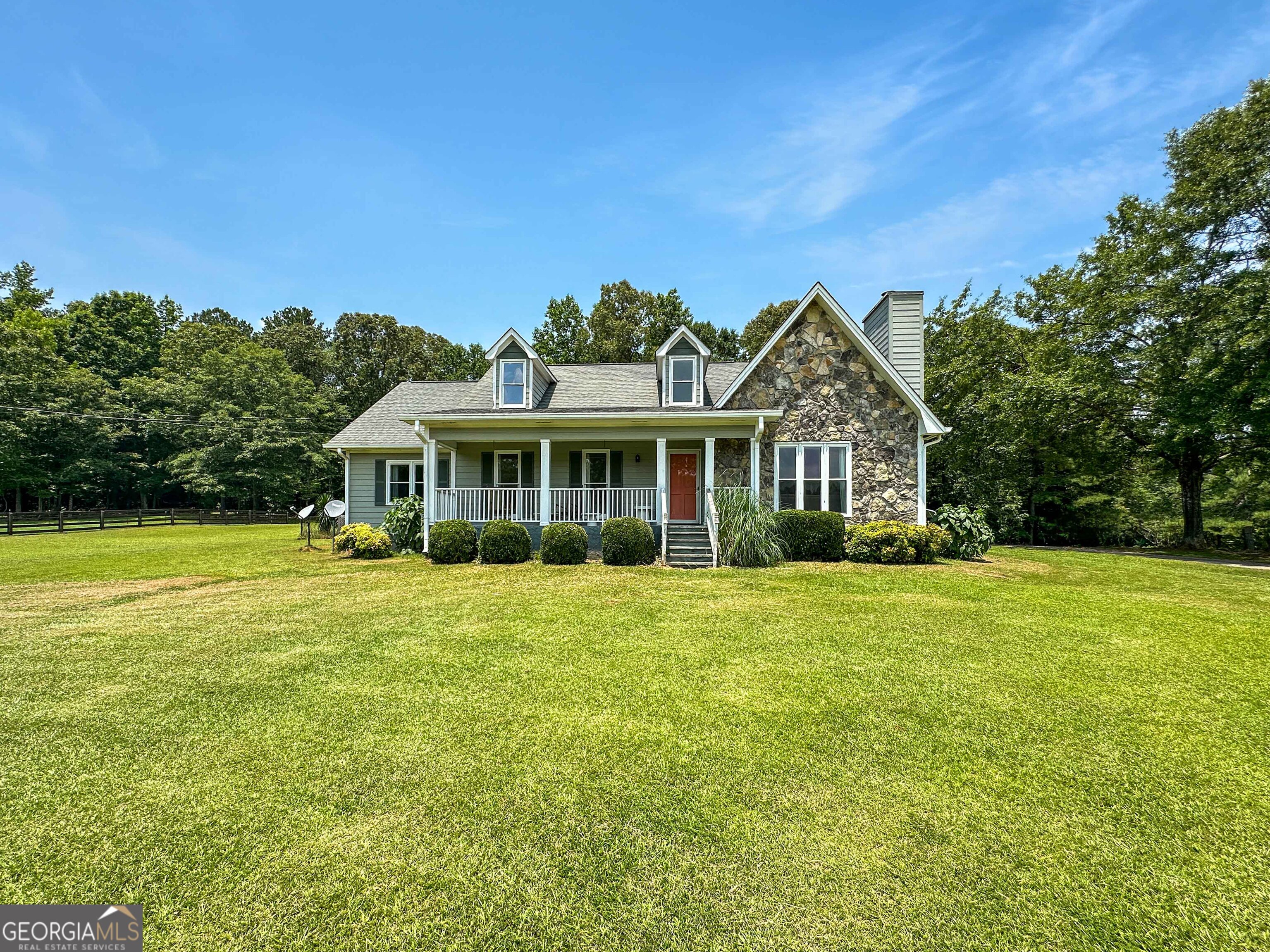 Privacy, Land, Upgrades, and a Pool = Your Own Slice of Paradise! Tucked away in the peaceful landscape of Chattahoochee Hills, this charming home rests on nearly 5 acres of scenic countryside. Step inside to a welcoming, light-filled living room that flows seamlessly into the dining area and kitchen, complete with a spacious pantry. On the opposite side of the home, your primary suite is a true retreat, featuring high ceilings, a large soaking tub, double vanities, a separate tile shower, and a thoughtful bonus...the laundry room is conveniently located right within the suite for added ease! Two additional bedrooms and a full bath round out the main level, offering smart functionality for everyday living. Upstairs, discover a sun-drenched oversized fourth bedroom with a walk-in closet and generous walk-in attic storage space. The detached two-car garage includes 30 Amp RV charging, workshop space, and extra storage connected to the main home by a breezeway that leads to your sparkling in-ground pool, perfect for summer days and peaceful evenings. If privacy, nature, and a slower pace of life are calling your name, this is the home you've been searching for. Just minutes from Serenbe, this location perfectly blends rural tranquility with modern-day convenience.
