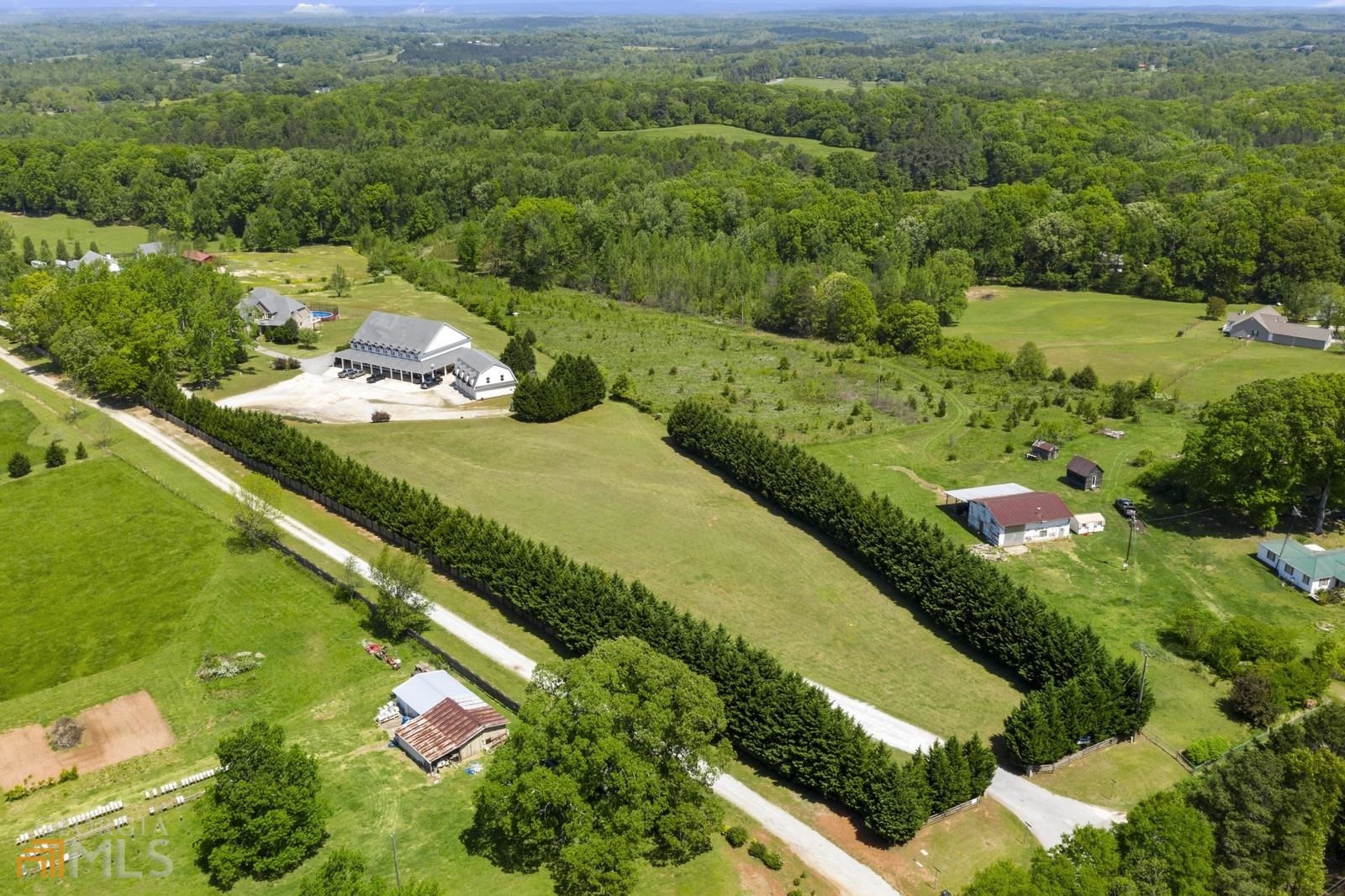 Possibilities are endless! If you are looking for a custom home, land, and a place for your hobby or business, look no further. This 8.86 acres property consists of 2 tracks (Zoned ARR) and has it all! This beautiful custom home has many features! Master on Main, oversized kitchen, keeping room with fireplace, dining room, family room with fireplace, large upstairs living room with fireplace, and a game area(pool table), second master upstairs with full bathroom and office, and many more features.   The large deck is partially covered, great for entertaining and overlooks the pool.The basement has a lots of storage/shelving and a boat door! This space can easily be finished for more living space.   There is over 4000 Sqft of Finished warehouse space to be used as a business or hobby! It has 6 office spaces, HVAC, bathroom, internet, Huge attic for storage space or other potential uses. Additionally, there is a separate 4 garage bays (1485 sqft)!  This unique property has potential for many uses!