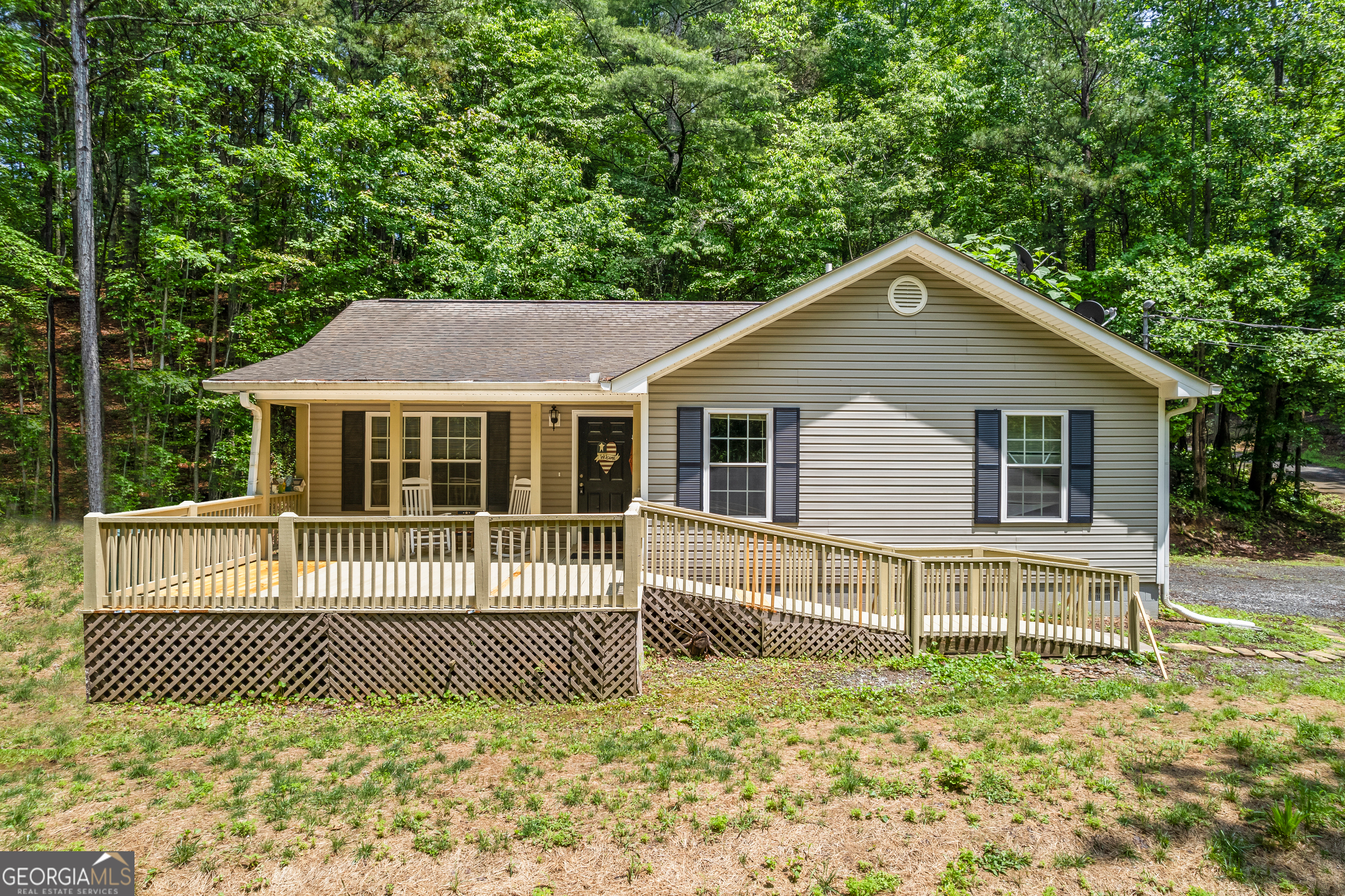 Back on buyers radar with fresh pricing! Looking for privacy and peace? This property has you covered! It can be your escape to your private mountain retreat in the beautiful North Georgia mountains of Ellijay. This 2-bedroom, 2-bathroom ranch-style home offers 1,152 sqft of comfortable living space on a 1.49-acre lot with NO HOA. An open-concept floor plan seamlessly connects the kitchen, living, and dining areas. The kitchen features a spacious island with bar seating, perfect for casual meals. This home has a large master suite with a private bathroom. With natural light shining in throughout the home, this creates a warm and inviting atmosphere. Nugget Lane has an expansive front porch ideal for relaxing and enjoying the peaceful wooded surroundings. The owner added a leveled and graveled parking area with a second driveway for added convenience. A natural spring on the property feeds the well, enhancing the home's sustainability. This home is located just a short drive from downtown Ellijay, providing easy access to local shops and restaurants. This home is surrounded by outdoor recreational opportunities, including hiking, fishing, kayaking, and exploring nearby apple orchards and wineries. 104 Nugget Lane is versatile for full-time living, weekend getaways, or short-term rentals.*Agents - Please use showing time to request appointments. Appointments are automatically confirmed*