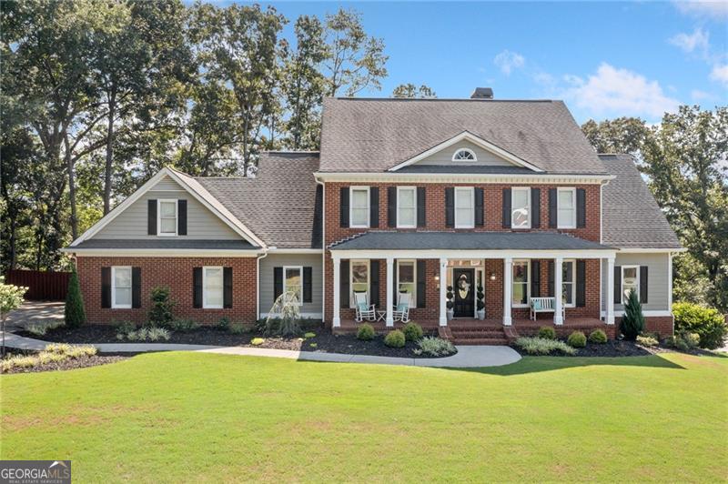 Nestled on a private half-acre lot in The Waterford, this brick-front home welcomes you with a gorgeous front porch-perfect for morning coffee or evening relaxation-leading into a formal entryway with a living room (ideal for a home office) and a separate dining room. The space flows into a dramatic two-story family room featuring a 20-foot wall of windows, built-in entertainment center, and a charming brick fireplace. The crisp white kitchen boasts a large island with gas cooktop, walk-in pantry, and breakfast room, plus a main-level laundry for added convenience. The oversized owner's suite on this level offers direct backyard access, an expansive walk-in closet, and a luxurious bath complete with a jetted tub and separate shower. Upstairs, three additional bedrooms and two full baths provide ample space for family or guests, while the fully finished daylight basement-with its own entrance-includes a fifth bedroom, full bath, and plenty of flexible space for a media, gym, or workspace area and a lot of storage space. Outside, unwind in your fully fenced backyard with new retaining walls, stone stairs, and fresh landscaping in this quiet cul-de-sac setting. Residents of The Waterford enjoy resort-style amenities: clubhouse, Olympic-size pool, tennis & pickleball courts, playground, party shelter, and cabana. Just across the street, Dellinger Park offers miles of running trails, city pool, courts, picnic pavilions, and a scenic pond. Zoned for Cartersville City Schools and minutes from downtown shopping, dining, and entertainment, 25 Westchester Drive perfectly blends classic craftsmanship, modern updates, and an outstanding community lifestyle.