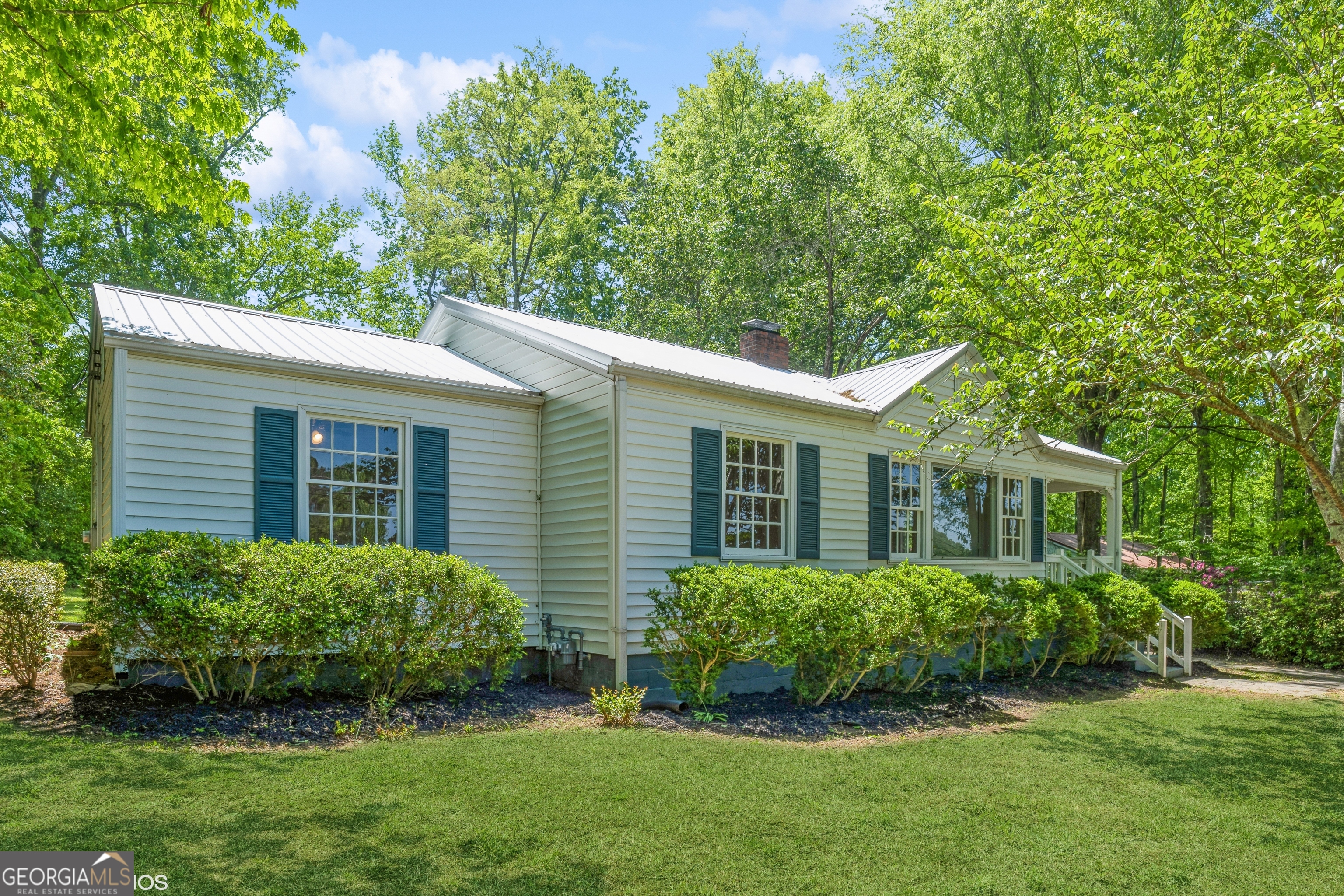 Charming white brick cottage with timeless appeal and modern updates. Enjoy the covered front porch and bright attached sunroom with floor-to-ceiling windows that flood the space with natural light. Refinished hardwood floors add warmth and character throughout. The fully updated kitchen features new cabinetry, a center island, granite countertops, and stainless steel appliance, perfect for everyday living or entertaining. The spacious living room and breakfast room both offer large picture windows, creating bright and airy spaces. This total electric home sits on a sloped lot with a rear driveway that easily fits two cars, offering both convenience and privacy. With its blend of cozy charm and stylish upgrades, this home is move-in ready and waiting for you to make it your own!