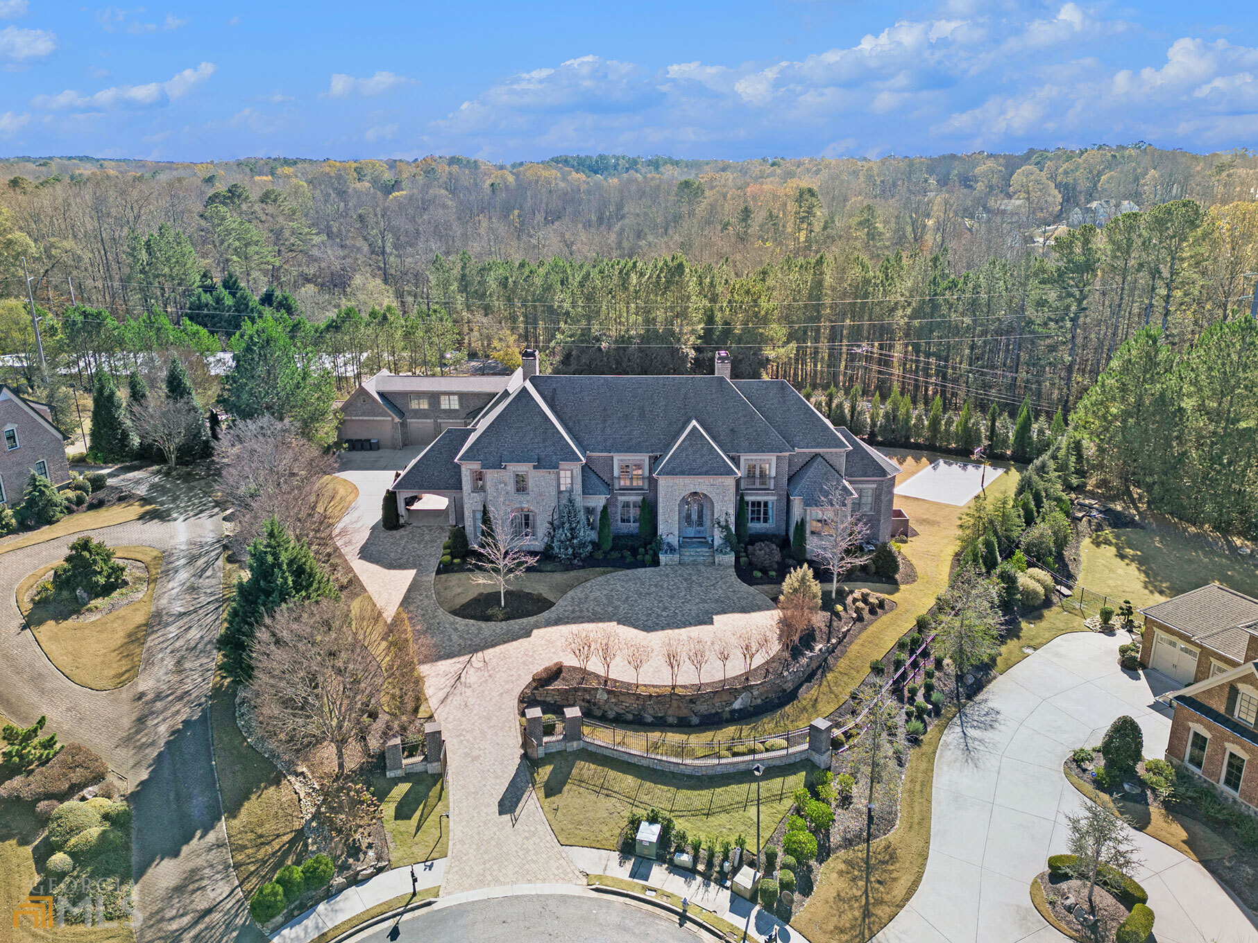 This spectacular estate will sell at Luxury AUCTION WITHOUT RESERVE on Sept. 1! ListA price for REFERENCE ONLY. Offered in co-op. with Platinum Luxury Auctions. Inquire for details. 310 Blair Court, where elegance meets entertainment. Nestled in the heart of one of Alpharetta's elite, gated Golf communities, this luxurious, gated-estate is resort-style living at its finest. It features stunning architectural and purposeful details with floor to ceiling windows that offer the perfect natural lighting throughout. The grand staircase to the upper level greats you at the main entrance. Designer kitchen by SieMatic that features Italian marble countertops and backsplash, 8-burner Wolf gas range and double ovens, pot-filler, SubZero Refrigerator, dishwasher, a breakfast bar, built-in coffee maker, eat-in nook, and walk-in pantry. The kitchen opens up to the family room that offers 1 of 4 fireplaces, stair-access to the upper level, and great views of the outdoor terrace and pool. The oversized owner's suite on the main, boasts a stone fireplace, sitting area, private patio that overlooks the pool, and two bathrooms equipped with steam/aroma showers, bidets, soaking tubs, and dual closets. A secondary en-suite on the opposite wing of the main level is a welcoming bonus. The main level also features a formal dining area, lounge area with additional stone fireplace, office/library with built-in bookshelves, main laundry room, and access to the 3-floor elevator. With three additional spacious en-suites on the upper level, an additional laundry room, and a great deal of attic storage, the possibilities are endless. Two of the three en-suites have their own balcony with views of the neighborhood, separate showers and soaking tubs, and huge walk-in closets. This Control4 smart home also has built-in surround sound & security throughout. Meticulously thought-out design from the Brazilian imported marble floors, smart, built-in appliances, and extravagant light fixtures and chandeliers. The full finished terrace level continues to unveil the shift in elegance of this home with your very own custom LED-lit wine cellar, eight-seat theater room, recording studio, game room, full kitchen with wet bar, dry sauna, gym, full en-suite, additional half bath, and more! The basement also has an additional room that can be utilized as an office or bedroom. An outdoor oasis that features a heated PebbelTec pool with swim-up bar, water slide & LED lighting. The outdoor kitchen is fitted with a 6-burner stainless steel grill, pizza oven, hibachi, refrigerator, chiller, and wash sink. Another great entertaining space that has a projector and screen, gorgeous lighting, outdoor bath and shower, basket ball court, two fire pits and multiple seating and lounging areas. Two-separate staircases lead to the upper-level open terrace, eight-car garage, garden, and access to the carriage house. The carriage house sits just above the garage and is the ideal private living quarters with a full bedroom, bathroom, full kitchen, living room, and additional unfinished storage space. The covered walkway and carport allows for easy access to and from the garage and the main house. The carport is the perfect size and doubles as an additional lounge area with the 2-4 person porch swing and outdoor seating. Peace and serenity follow as the Khoi pond is just a few feet away. This home is perfect for entertaining as well as retreating from it all, into your own oasis. Everything you could need is centrally located with easy access to HWY 9 and 400, The Forsyth Collection, Halcyon, Avalon, Downtown Alpharetta, The Greenway, groceries and shopping. The Manor Golf and Country Club offers a Tom Watson designed golf course, clubhouse amenities, and an award-winning indoor/outdoor tennis program!