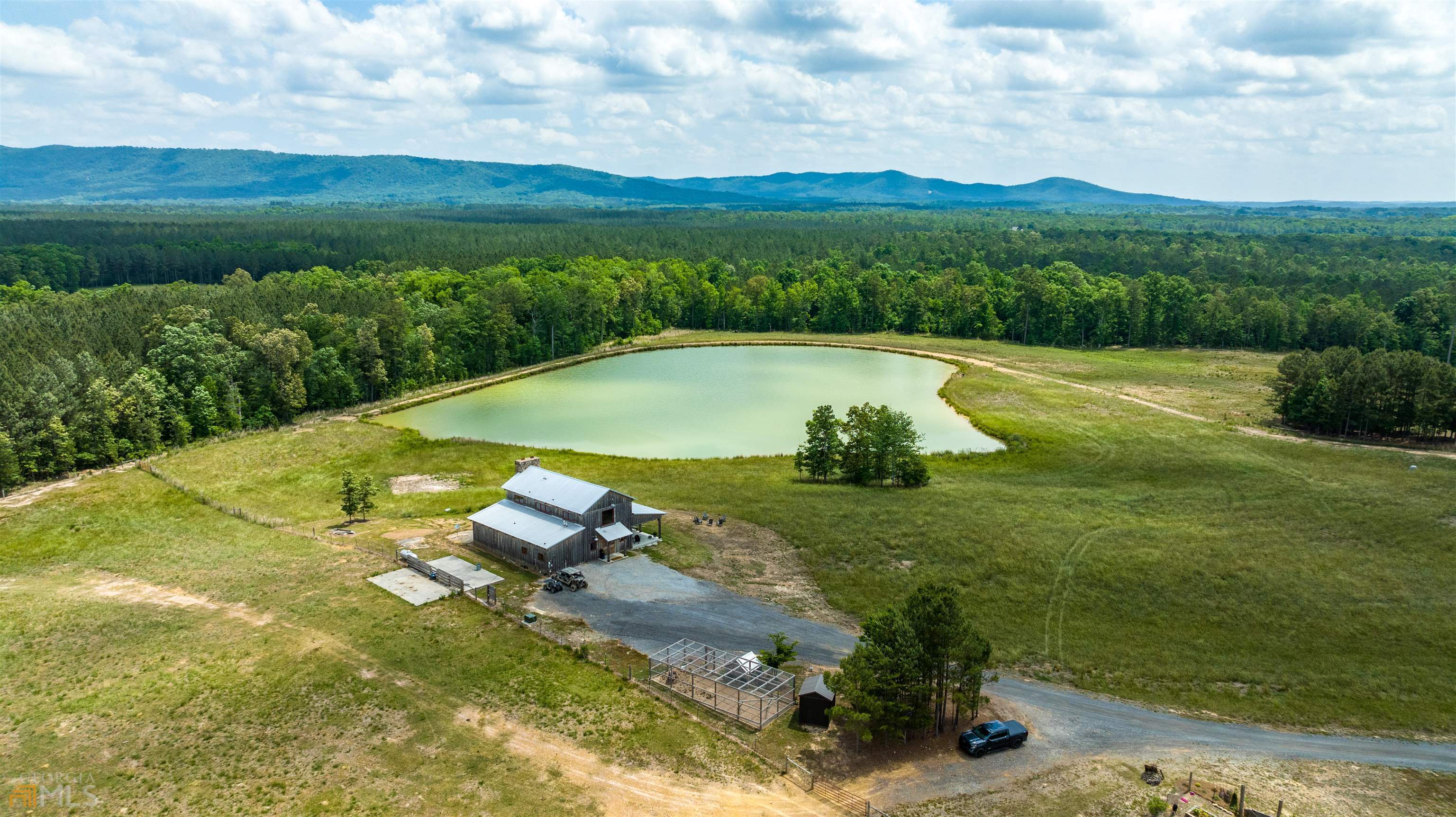 Absolutely Amazing is a huge understatement. This is the most beautiful piece of property I have ever had the opportunity to work with. This 354 acre working cattle farm has 360 degree mountain and valley views. The 3 bedroom 2 bath custom, top of the line, home sits in the middle of the property overlooking a stocked 3+ acre private lake. There are 10+ miles of fencing in the 270+/- acres of pasture. 3 wells on the located on the property that service 7 concrete on demand water pads located in the pastures for easy watering of your livestock. Ready to work your animals. All the pastures are paddocked with an easy transition into the covered and enclosed 8,800 sf livestock working barn. The livestock barn has built in gate systems, head catches, and weight scales. All will remain. There are also 2 large hay barns that can hold over 1,000 round bails of hay. The farm also features a chicken coup, quail raising pen, equipment barn, and multiple other water sources. This farm is truly spectacular and ready for anything. Don't need that much land? There are 2.5+/- miles of road frontage and county water available. This would give the buyer the option to split this farm up and sell off smaller tracts to recoup some of your investment.