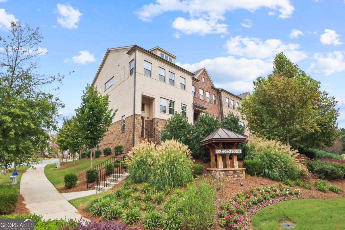 END UNIT with Tons of natural light! Discover modern luxury and convenience! This 4 Bedrooms 3.5 bathrooms three-story townhome provides flexible living spaces. The first floor offers a private bedroom and full bath, perfect for a guest suite, home office, or a family member seeking a quiet retreat. The second floor is the heart of the home, featuring an open-concept design that seamlessly blends the sun-filled living room, dining area, and a gourmet kitchen, which opens out to the deck with a fabulous view of the community. The third floor is dedicated to rest and relaxation. A spacious owner's suite provides a peaceful sanctuary with a spa-like ensuite bath. The third floor also includes two additional bedrooms and another full bathroom, offering plenty of space and privacy for the entire family. The home features beautiful hardwood and carpet flooring, a fireplace for cozy evenings, and modern fixtures throughout. Situated less than a minute from I-575, this home offers an incredibly easy commute. You're also just a short drive from the Woodstock Outlet Shoppes at Atlanta, Costco, and a variety of other shopping and dining options. Enjoy the vibrant charm of downtown Woodstock, which is within walking distance and offers a plethora of restaurants, boutiques, and community events. This property is zoned for excellent Cherokee County schools, including Woodstock Elementary, Woodstock Middle, and Woodstock High School. Residents of this community enjoy access to a swimming pool, and the HOA fee includes landscaping and trash services, providing a low-maintenance lifestyle. Don't miss your chance to own a piece of Woodstock's best.