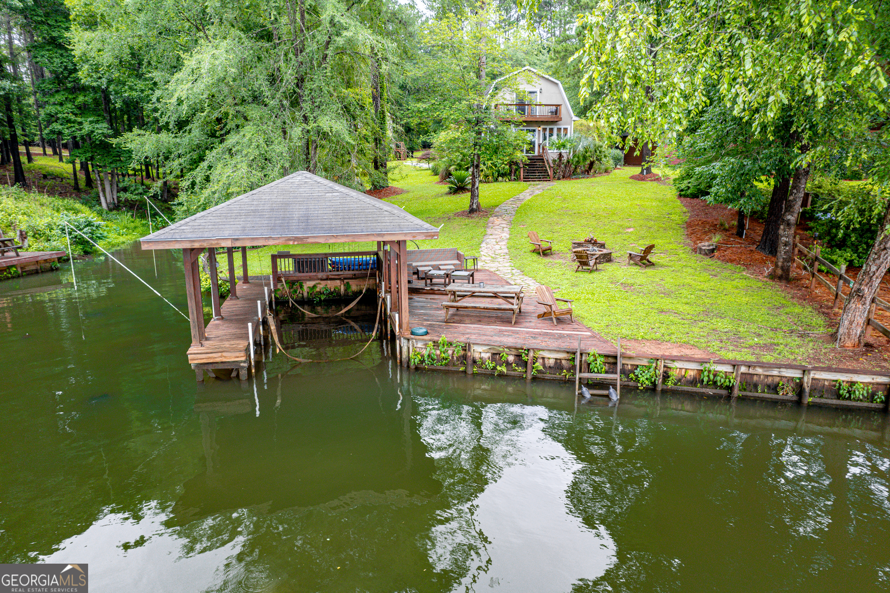 TWO-IN-ONE OPPORTUNITY ON LAKE SINCLAIR W/ $10,000 IN CLOSING COSTS! PHENOMENAL SHORT TERM RENTAL OPPORTUNITY! This property is special - it can be utilized a number of ways... short term rental (check with Putnam Co on permits), a vacation home with a guest quarters above the garage (featuring 2 bedrooms, 1 bathroom and a kitchennette) or a mixed use - use one and rent the other! The main house has new appliances, 2 bedrooms, 1 bathroom, a flex space used as an office/game room/lounge area, a cozy living room and a lakeside sunroom. Outside, there's a hot tub area for entertainment and a single stall boathouse with a hangout area at the dock and boatlift in place for your boat! Firepit area close to the water which is perfect for lake nights. This home is located in the Rockville Springs area of the lake - known for it's super calm, super clean water, amazing neighbors and very close proximity to Oconee Springs Park! Just a short stroll to Lake Oconee, Eatonton and Milledgeville... this is the PERFECT Lake Sinclair property!! Call today and let's get you SOLD on this piece of Sinclair!!!