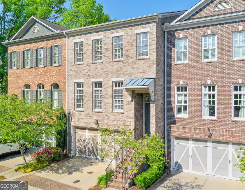 Live in the Heart of Vibrant Downtown Alpharetta! Tucked away in a quiet and private enclave, this stunning townhome offers the perfect blend of luxury, comfort, and style. From the moment you step inside, the bright and airy open floor plan invites you in-designed with both entertaining and everyday living in mind. The main level showcases gorgeous hardwood floors, stunning millwork and a beautifully appointed modern kitchen featuring white cabinetry, sleek stone countertops, stainless steel appliances, a spacious center island, and a generous pantry. The expansive dining area is bathed in natural light, while built-in bookshelves frame a cozy fireplace in the living room, creating a warm and inviting space. Step out from the great room or breakfast area onto a private deck-perfect for grilling or relaxing-overlooking a fenced-in backyard and tree-lined views, your own peaceful retreat in the city. Upstairs, you'll find three thoughtfully designed bedrooms, including a luxurious primary suite with a walk-in closet and spa-inspired en-suite bath. The lower level offers even more flexibility with a large bonus room that can serve as a fourth bedroom, media room, home gym, or office, complete with a full bathroom and direct access to a covered patio and beautifully landscaped backyard. Additional features include a deep two-car garage with storage space, a long driveway, and ample guest parking nearby. Enjoy the best of Alpharetta right outside your door-walk to shops, restaurants, parks, and year-round festivals. This is low-maintenance luxury living in an unbeatable location. Don't miss the chance to make this exceptional property your new home!