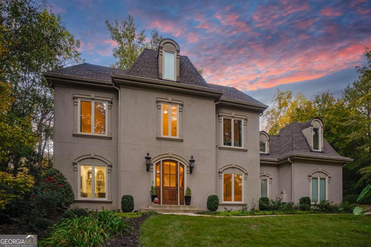 Tucked away on a private lot in the highly coveted Atlanta Country Club, this stunning 5-bedroom, 4.5-bathroom home (6503 sq ft) and separate pool house (approx. 670 sq ft) seamlessly combine luxury with modern functionality. Thoughtfully designed and extensively updated, this home is ideal for those who value style, comfort, and convenience. Nestled at the end of the private driveway, this hard-coat cement stucco home sits on almost one acre. The customized iron gate and manicured landscaping enhance the beauty and privacy of this executive home. As you enter the grand two-story foyer, you are flanked by both a sophisticated home office with floor-to-ceiling custom cabinetry and the formal dining room with a trey ceiling. The massive living room, complete with a fireplace, built-ins, designer chandeliers, and multiple sets of French doors, is a showstopper. You'll appreciate the flow and aesthetic of the newer hardwoods running throughout a majority of the home. The main level showcases a brand-new chef's kitchen with white cabinetry, a massive island with premium waterfall quartz countertops, high-end stainless-steel appliances, an ice machine, a wine cooler, and a wet bar. You'll love the openness to the sundrenched dining area, an entertainer's dream. With a convenient exterior door to the pool, this fabulous space anchors the kitchen and screened-in porch, making it ideal for gatherings and daily life. Step outside to enjoy the serene plunge pool or the well-appointed pool house. With 1.5 bathrooms, this freestanding guest house was designed for short visits or long stays. The outdoor fireplace, extra-large deck (approximately 300 sq ft), and convenient half bath with interior/exterior access make entertaining a breeze. Inside, the guest house includes a kitchenette, full bathroom, and laundry-perfect for guests, independent living, or potential rental income. Back in the main house, you'll find four bedrooms and three full bathrooms, including the primary suite upstairs. The owners' suite impresses with a trey ceiling, fireplace, and built-in bookcases. The extra-large ensuite features a soaking tub, stand-alone shower with natural light, an extra-long double vanity, make-up table, and water closet. This spa-like retreat includes an expanded walk-in closet with a new island addition for added storage. Additionally, three other bedrooms offer ample closets and two updated bathrooms. The "bunk room" features a gorgeous accent wall and built-in bunk beds for added fun. The fully finished basement includes a temperature-controlled wine cellar, custom bar, billiards table, home theater, fifth bedroom, full bathroom, and versatile flex space with French doors to a patio-easily converted to a sixth bedroom or gym. This area offers endless possibilities for entertaining, working, or even as a guest suite. Updates such as newer windows, doors, HVAC system, water heater, and roof provide comfort and peace of mind. The landscaped exterior includes a parking pad, reinforced support wall, new basement patio, updated front steps and walkway, and sophisticated nightscape lighting for captivating curb appeal. Located in a top-rated school district, this home is zoned for some of East Cobb's best schools: Walton, Dodgen, and Mount Bethel. Optional membership to Atlanta Country Club includes access to newly renovated golf and practice facilities. Proximity to Chattahoochee River National Recreation Park, Sandy Springs dining, The Avenue at East Cobb, downtown Roswell, Truist Park, and more makes this a prime location. Don't miss this opportunity to call this unique property home!