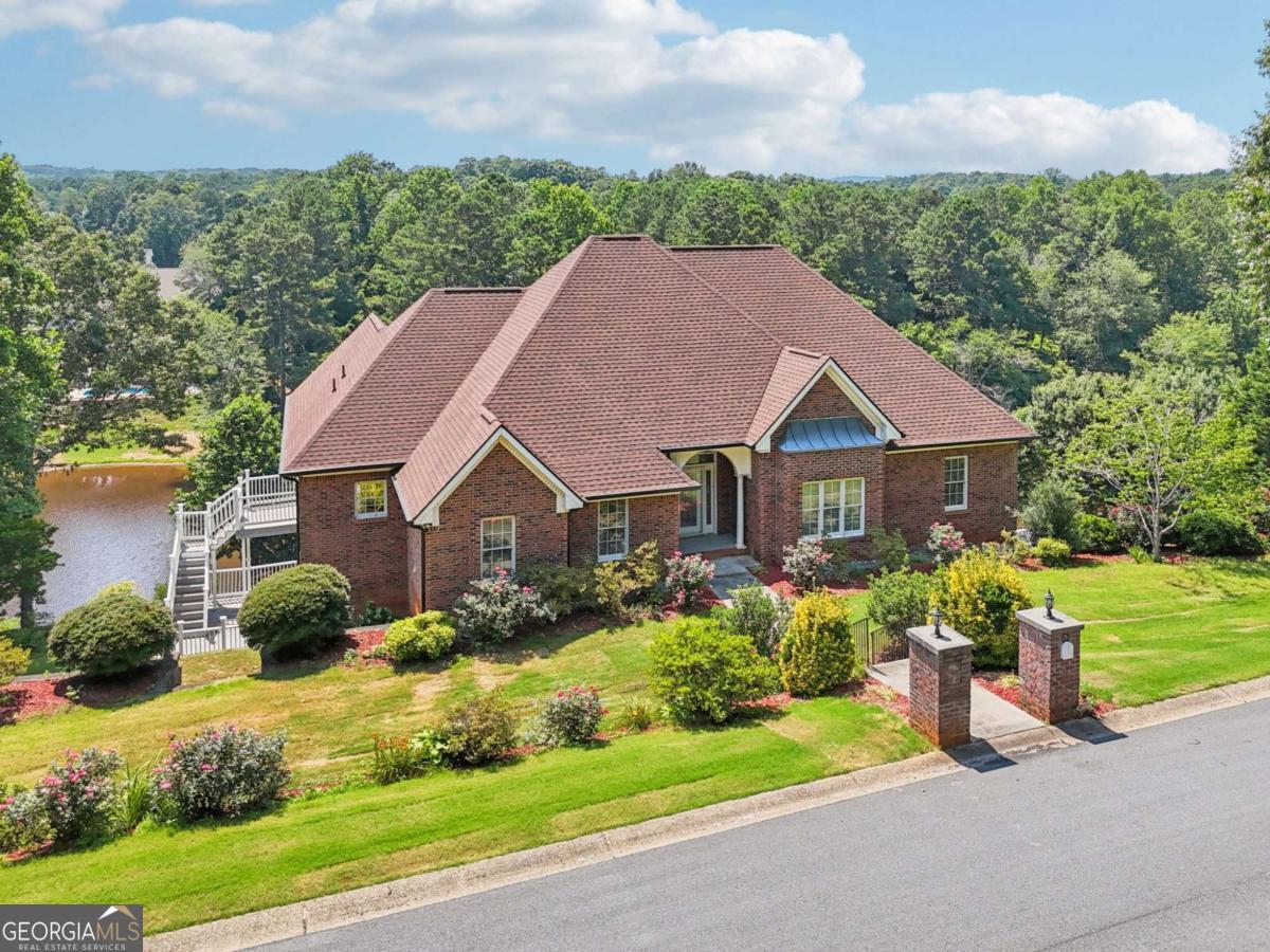 Listed Well Below Appraised Value! Stunning multi-level lakefront home on Spring Lake with breathtaking views and upgrades throughout. Hardwood floors on both levels, no carpet! Main living area features crown molding, fireplace, built-ins, formal dining, and multiple access points to the expansive lakefront deck. The chef's kitchen includes a large island with seating, gas cooktop, double ovens, stainless steel appliances, stone countertops, and a walk-through pantry to the oversized laundry/mudroom. Luxurious primary suite offers a see-through fireplace, tray ceiling, private deck, dual walk-in closets, and spa-like bath with double vanities, garden tub, and custom tiled shower. Two secondary bedrooms share an updated double-vanity bath. Lower level features a huge family room with lake views and deck access, plus three bedrooms (including a Jack-and-Jill bath). Massive 3-car garage, abundant storage, and unfinished spaces with a nearby full bath provide endless possibilities. Outside: multi-tiered backyard, private dock, mature trees, and direct lake access for fishing, boating, or relaxing. Don't miss this rare opportunity-schedule your showing today!