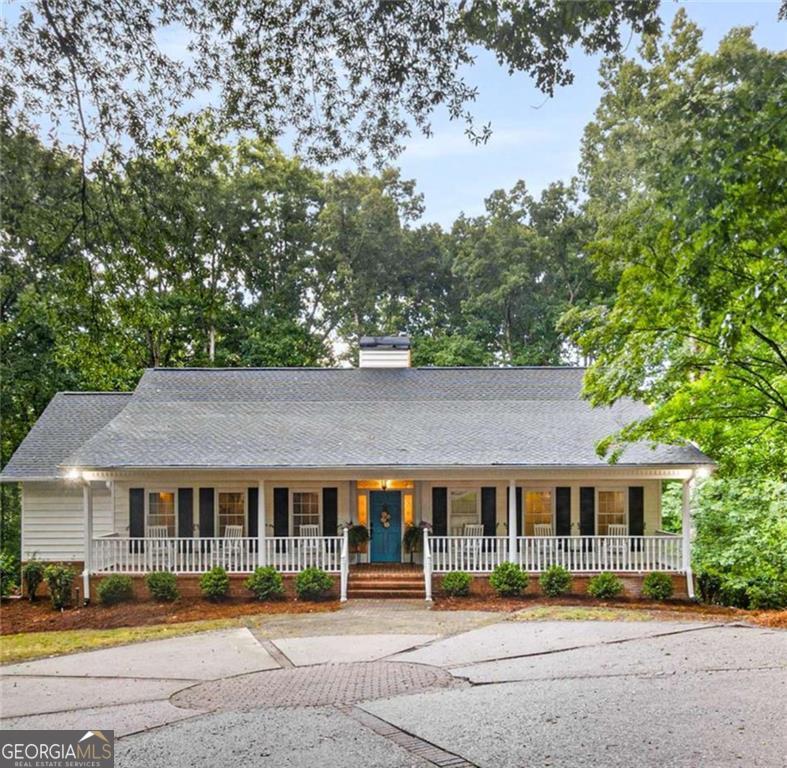 Welcome to this stunning 4-bedroom, 3-bath Ranch home on a beautifully finished terrace level that offers the perfect blend of southern charm and modern comfort with seasonal lake views and lake access! The inviting covered front porch, complete with rocking chairs, extends the full length of the home and sets the tone for relaxed living, just add a glass of sweet tea and enjoy these evening summer storms. Inside, the bright white kitchen features granite countertops and an abundance of cupboard space and natural light from windows throughout the home. The spacious vaulted family room, accented with wood beams, flows seamlessly with real hardwoods throughout the top floor. The spacious primary suite is conveniently located on the main level with a shiplap, updated primary bathroom and an amazing walk-in closet. Just follow the path down to the lake with your kayaks that can be stored under the covered patio off the terrace level. Downstairs you'll also find 10 ft ceilings, a large spacious family room, 2 bedrooms and a full bath which can be great for family visitors. Bonuses include the expansive Trex deck off the kitchen which is perfect for outdoor gatherings, while the side-entry garage and large front parking pad offer plenty of parking options. This home has over $43K in updates and combines character, space, and functionality in a prime setting. Don't miss your chance to make it yours!