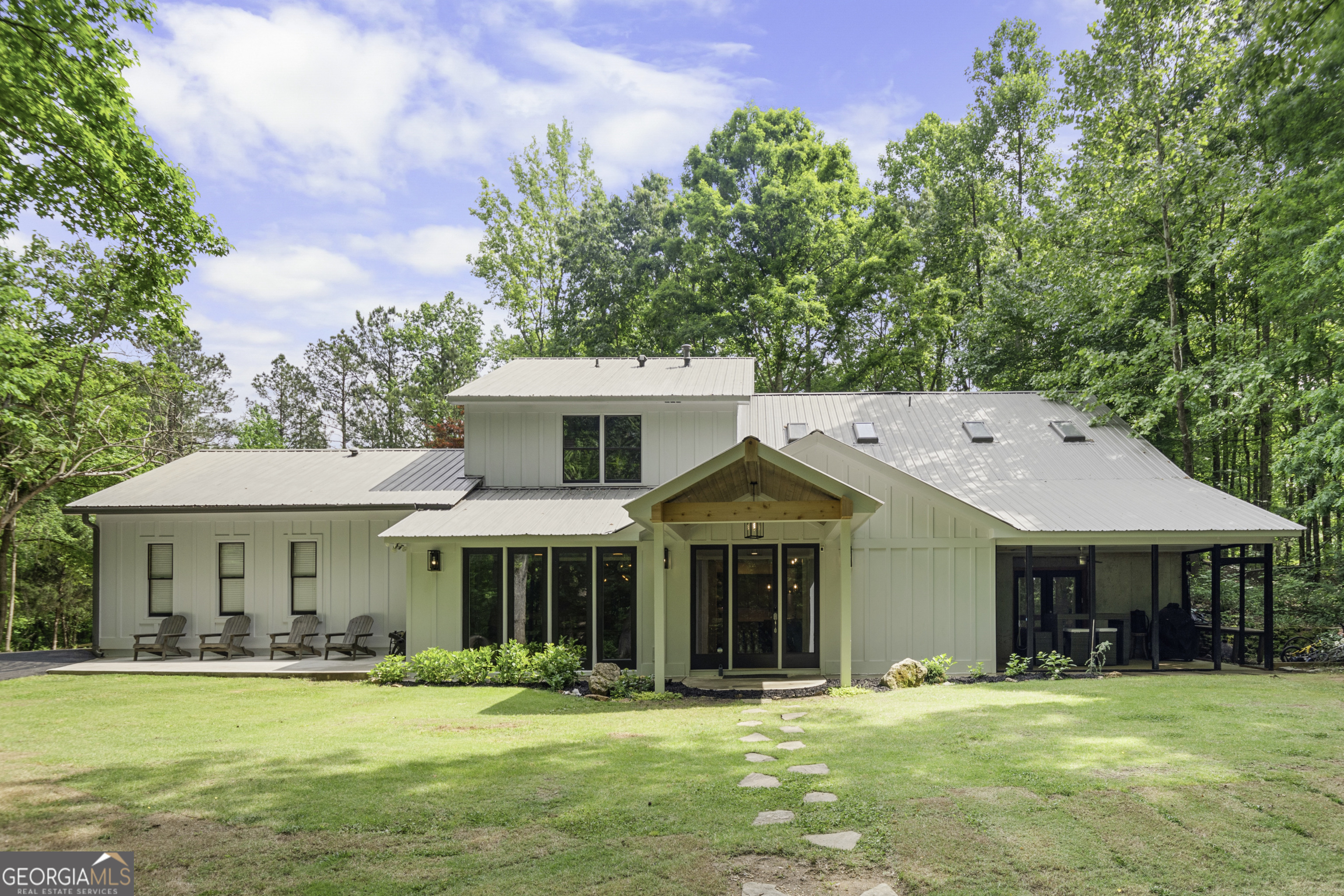 Welcome to your own slice of paradise in Woodstock, GA! Nestled on 4.57 acres of lush land, this unique property offers a perfect blend of serene privacy and modern comfort. Originally built in 1997, this home underwent a full renovation in 2019, embracing the timeless charm of farmhouse design with an airy open concept layout. The home features, 4 bedrooms and 3 baths, including a master suite on main featuring a beautifully tiled walk-in shower. The spacious kitchen is the heart of the home, featuring custom grey cabinetry, an expansive island topped with exquisite leathered granite, and top-of-the-line appliances. With water and electric already run to the front of the property, the potential for expansion is limitless. The unfinished storage area presents an opportunity for a future guest suite complete with bath, kitchen, and laundry facilities, adding even more versatility to this already impressive property. Located in top schools and less than 15 minutes away from local craft drink, food and lively entertainment of downtown Woodstock, this property is truly a rare find with limitless possibilities.