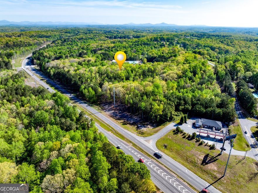 Prime Commercial Land on GA Hwy 400 - 19.45 Acres in Dawsonville, GA  Exceptional opportunity to own 19.45 acres of commercially zoned land (C-HB) with incredible visibility and access in one of North Georgia's fastest-growing corridors. This expansive tract features approximately 1,330 feet of road frontage along GA Hwy 400 and an additional 150 feet on Grant Road, offering multiple access points and high development potential.    Strategically located just 1.5 miles from the North Georgia Premium Outlets, this property benefits from strong traffic counts, excellent exposure, and proximity to major retailers, restaurants, and residential developments. With its C-HB zoning (Highway Business Commercial), this site is ideal for a wide range of commercial uses including retail, hospitality, automotive, and service-based businesses.    Key Features:    19.45 Acres of level to gently rolling terrain    Zoned C-HB (Commercial Highway Business)    Approx. 1,330' of frontage on GA Hwy 400    Approx. 150' of frontage on Grant Road    High-traffic location near major commercial hubs    Don't miss this rare chance to secure a premier commercial site with unmatched highway exposure in booming Dawson County.